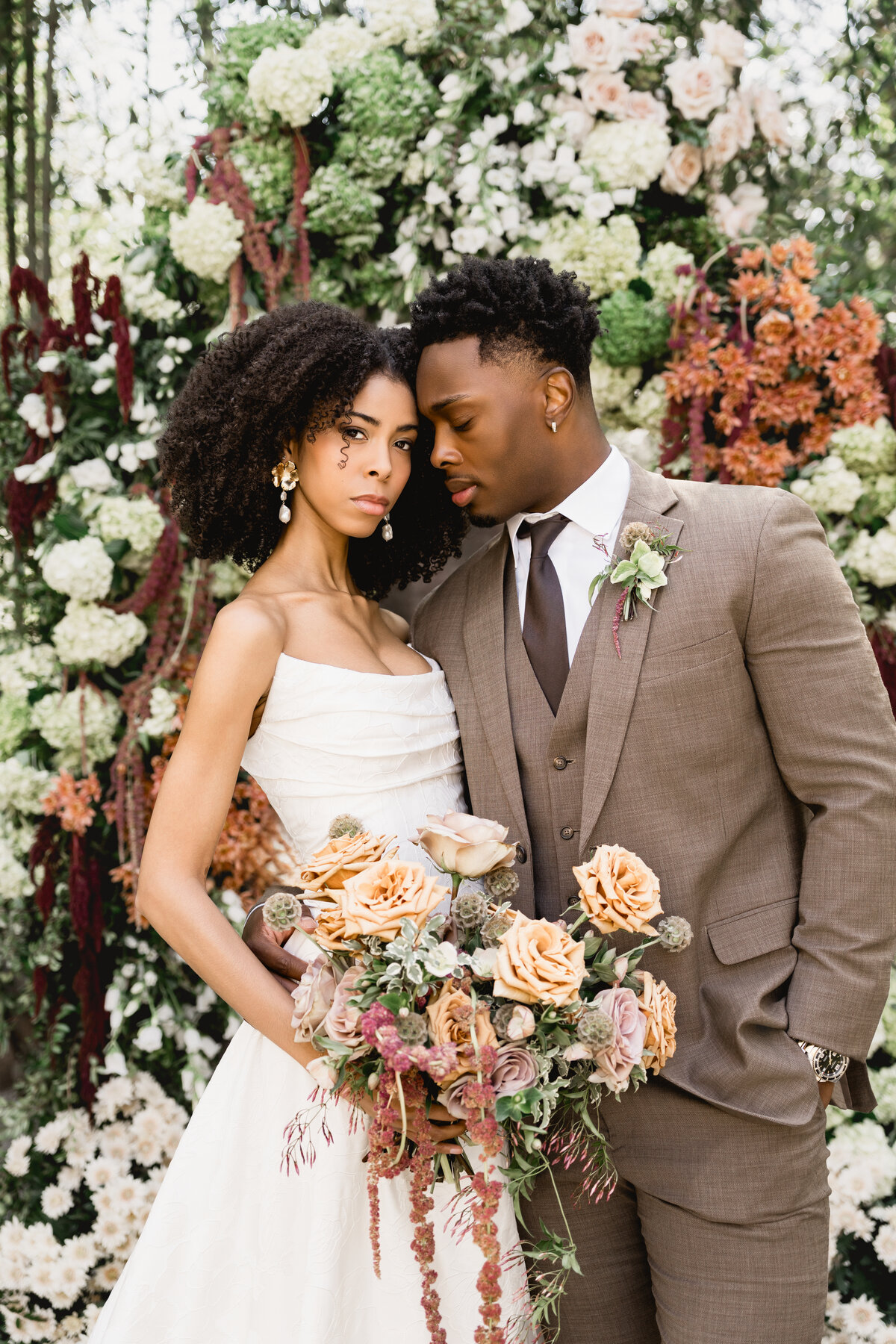 Couple posed in front of a floral installation