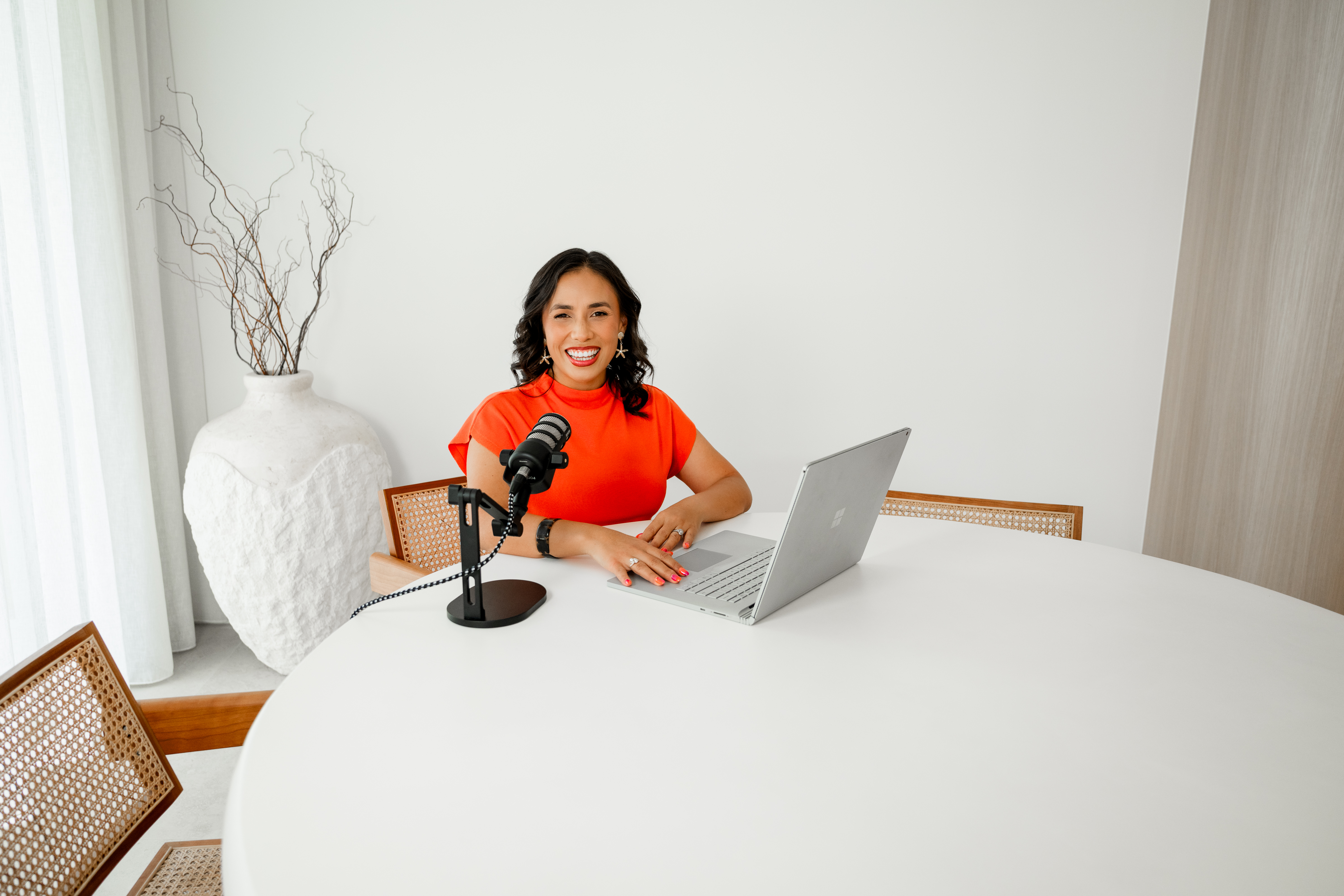 Jaleesa Paine at her desk with a podcast microphone