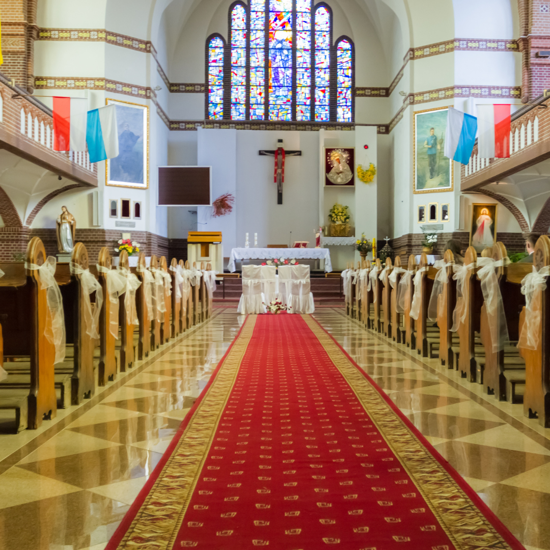 Long carpet running between pews with an alter in the cross in the distance