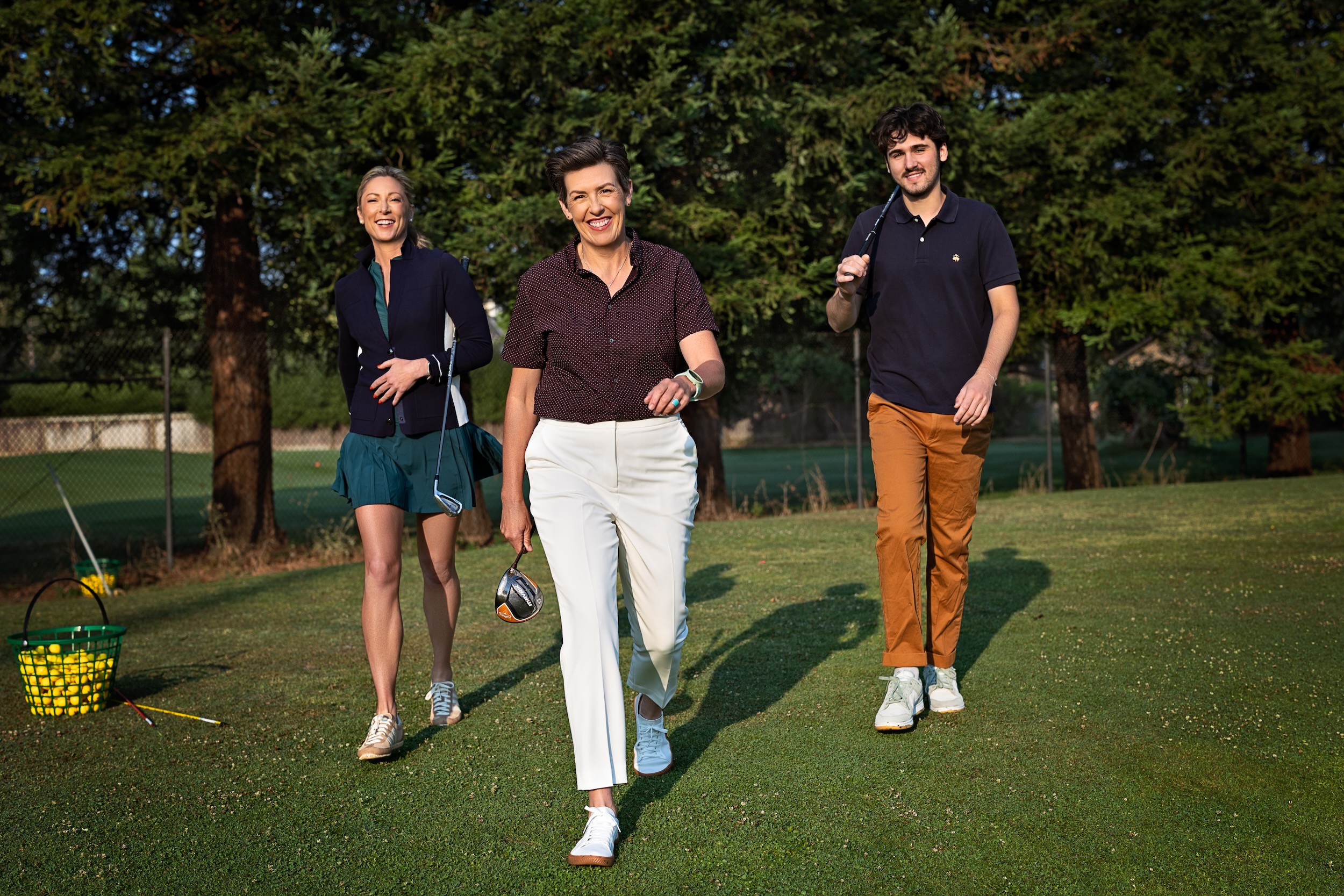 Amanda walking the golf course with two golfers