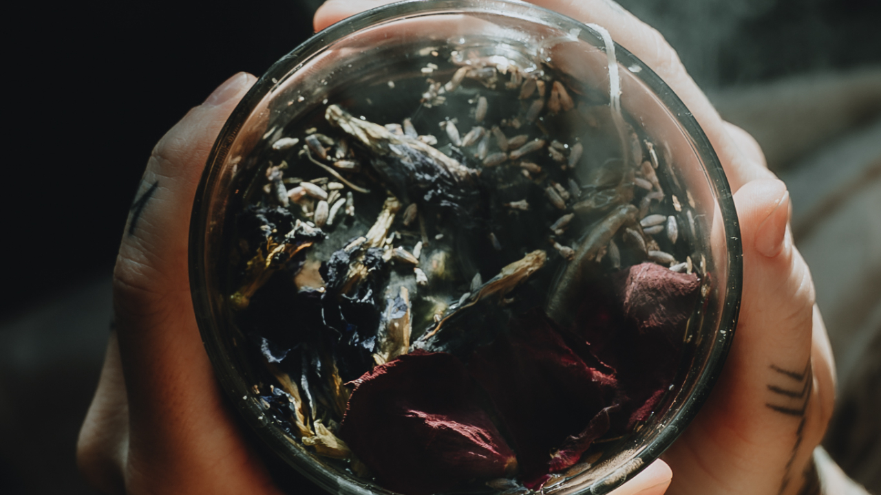 Hands holding a steaming cup of ritual microdosing tea