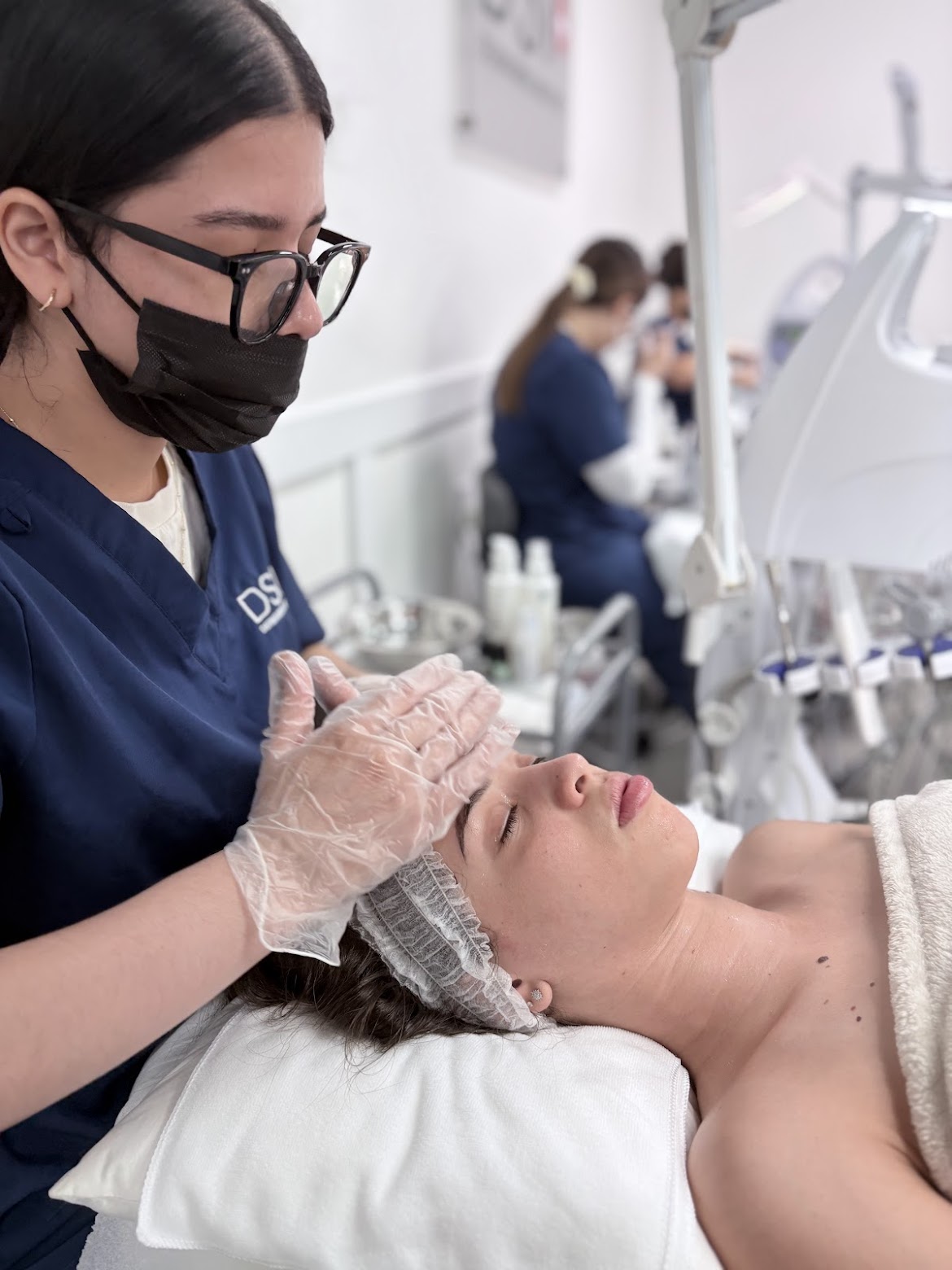 Student practicing a facial massage on a client at DermaSwiss Institute