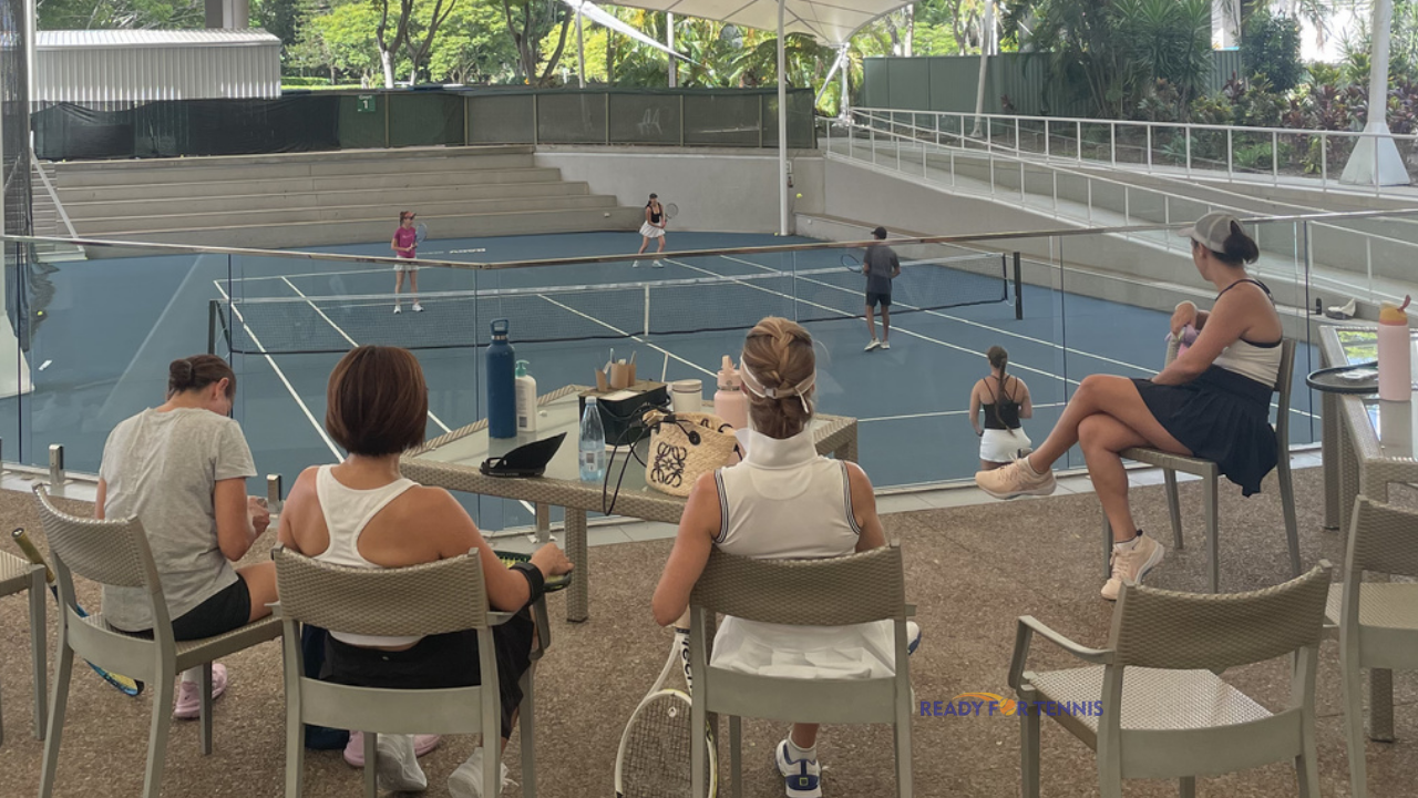 Adult tennis players smiling together on court at Ready for Tennis, showing the social and welcoming side of staying active through tennis on the Gold Coast.