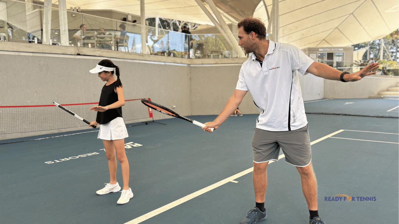 Image of Tennis Coach with a Junior Tennis Player showing the forehand technical fundamentals on an Indoor Tennis Court on the Gold Coast in Queensland, Australia
