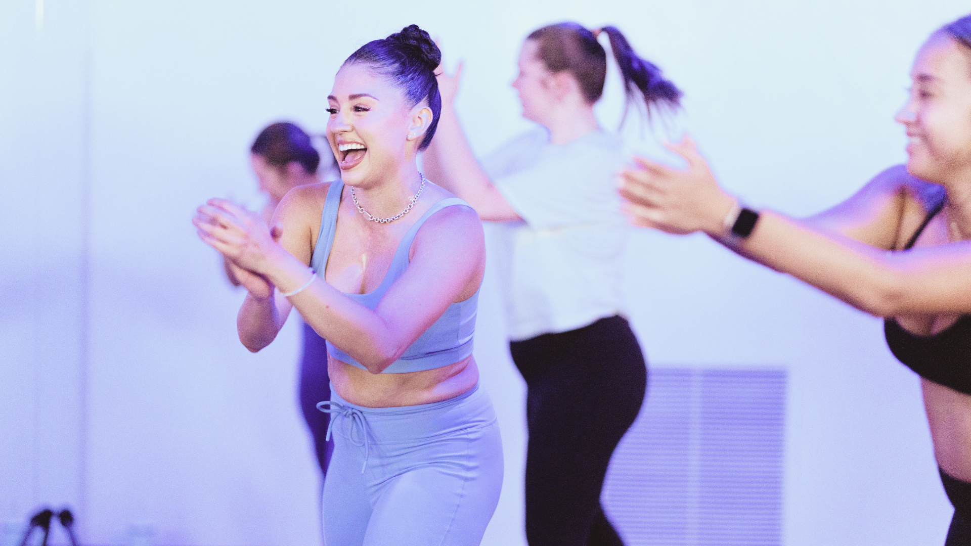Students participating in an energetic barre class during a mindful movement and strength training practice