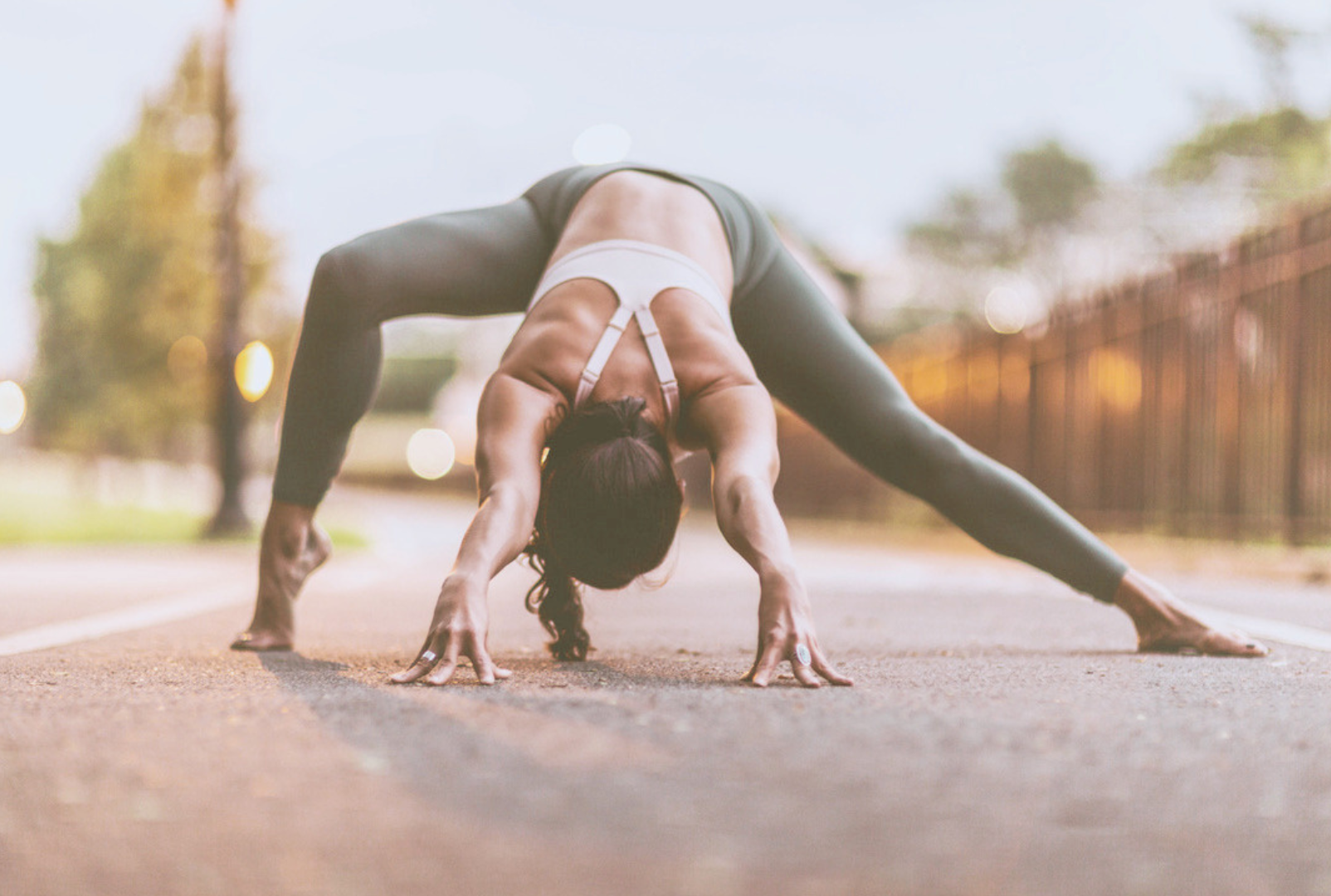 Yoga practitioner demonstrating a wide-legged forward fold during a mindful movement and flexibility practice outdoors