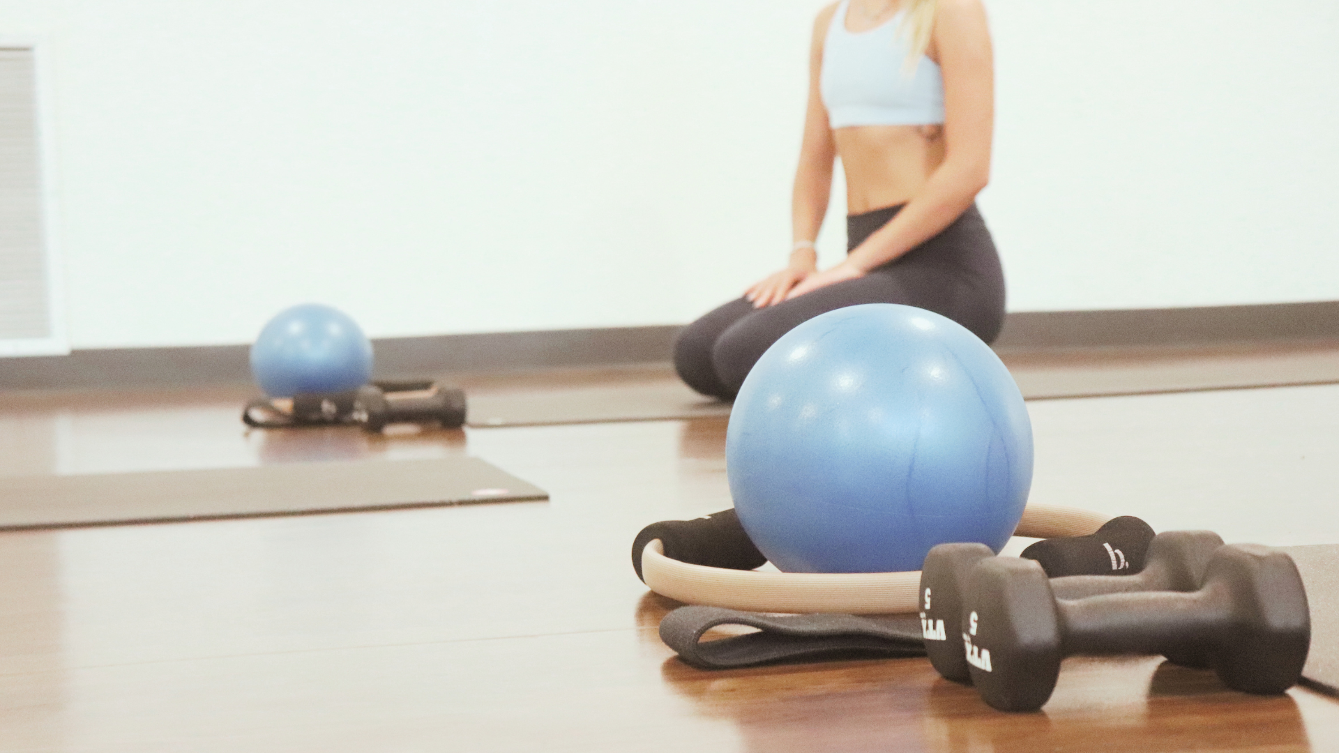 Barre training equipment including stability balls, Pilates rings, resistance bands, and light weights used for mindful movement classes