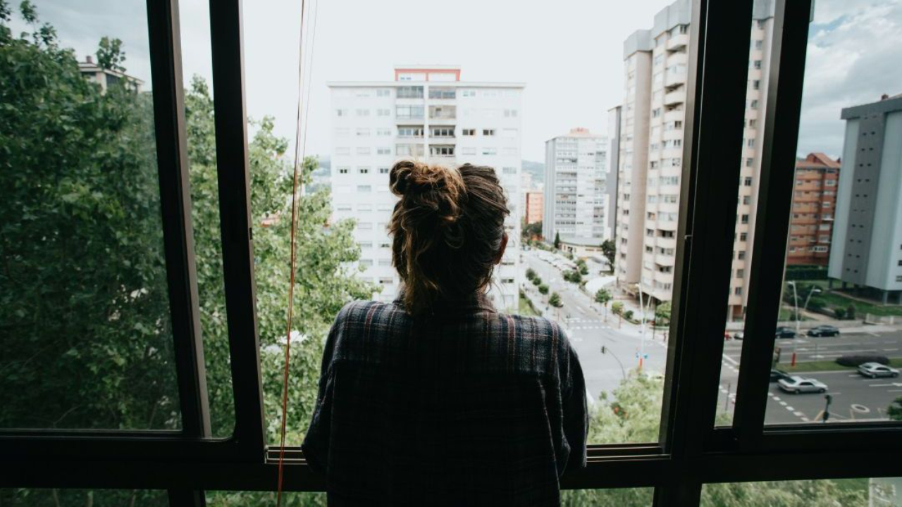 Lady looking out the window at the city