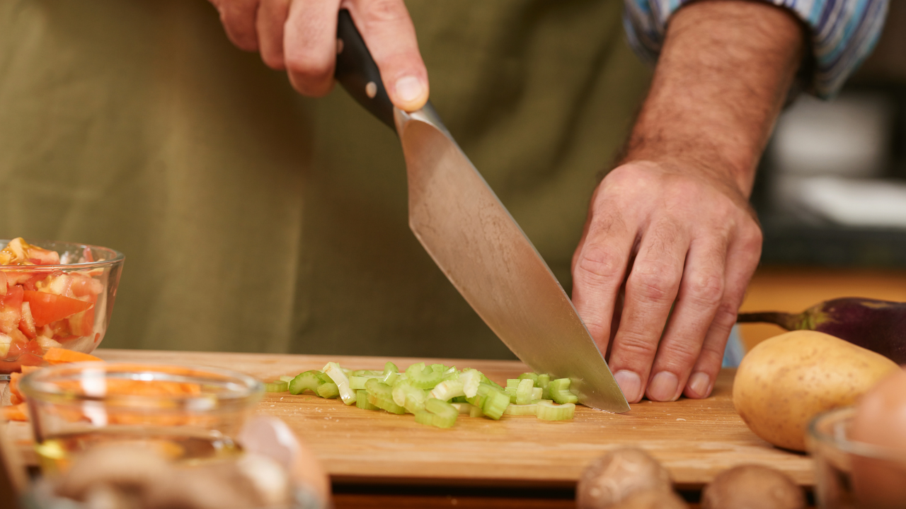 photograph of a chef with a knife on a wooden board, representing craft, preparation, and emotional dexterity in leadership