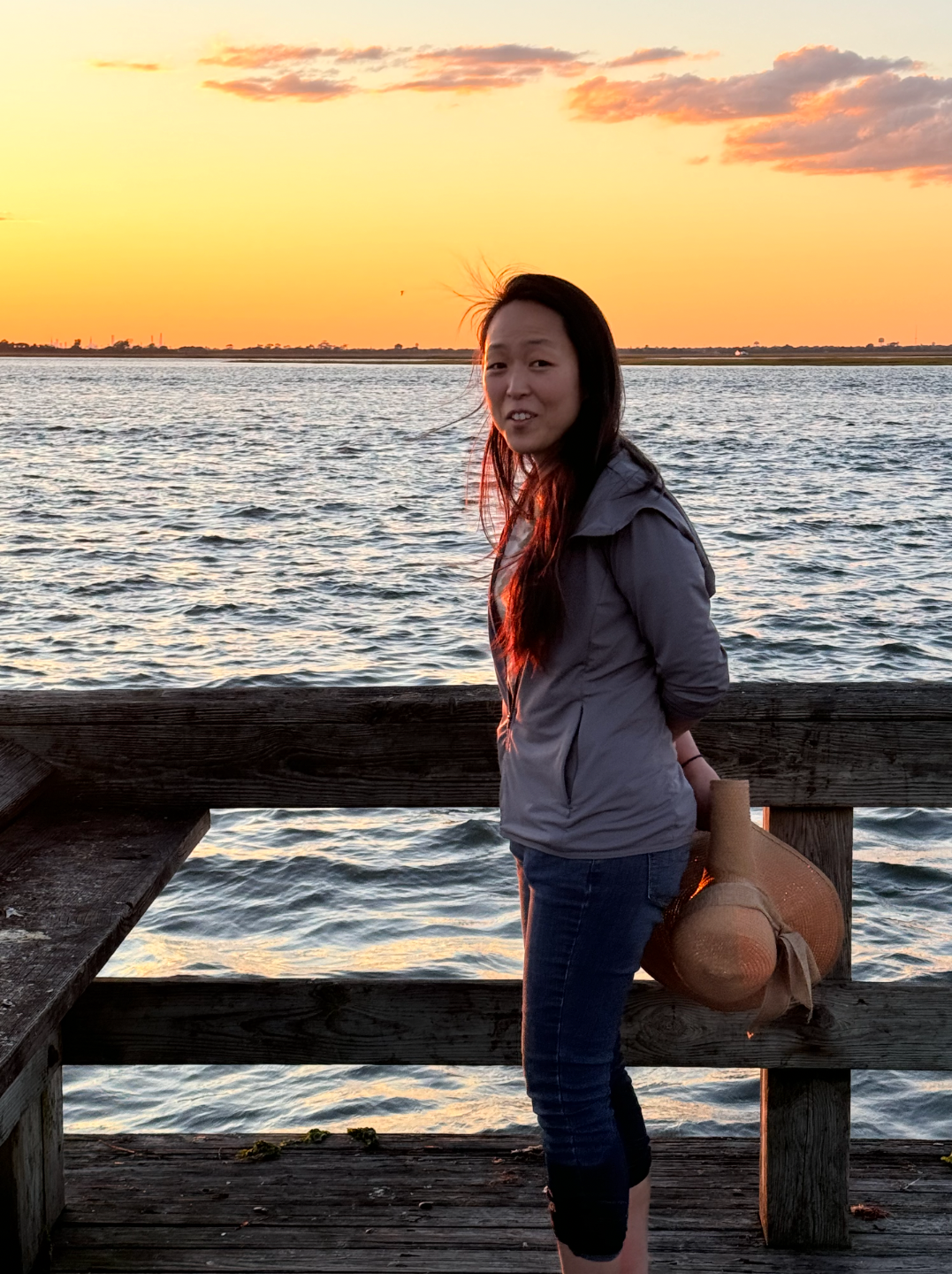 Jane at golden hour by the water, standing still in the light