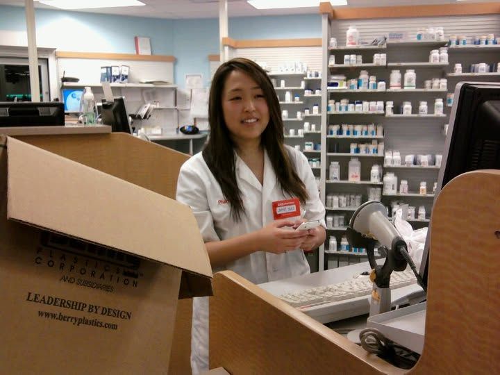 Jane in a white coat at the pharmacy counter
