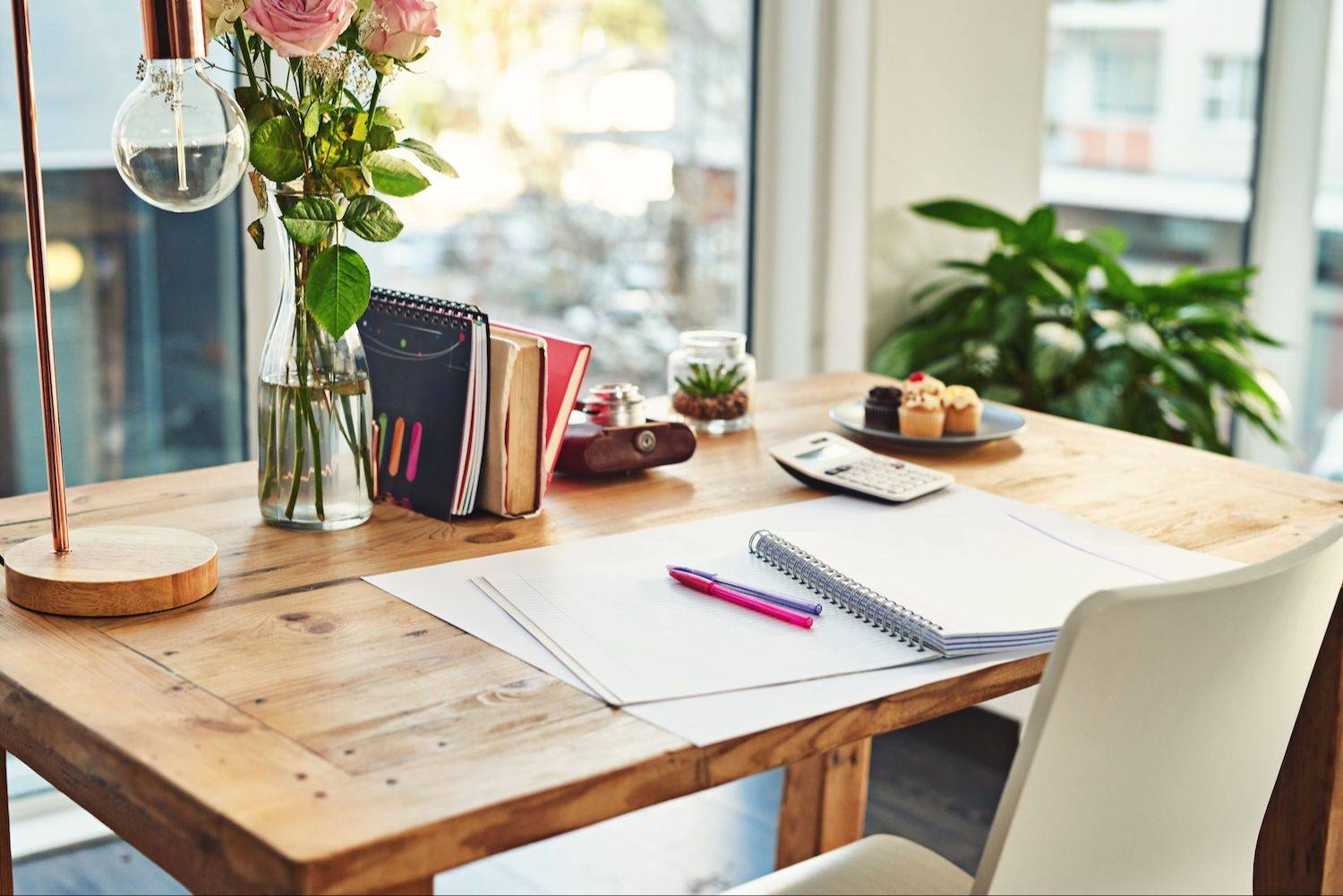 Open notebook on a desk with flowers