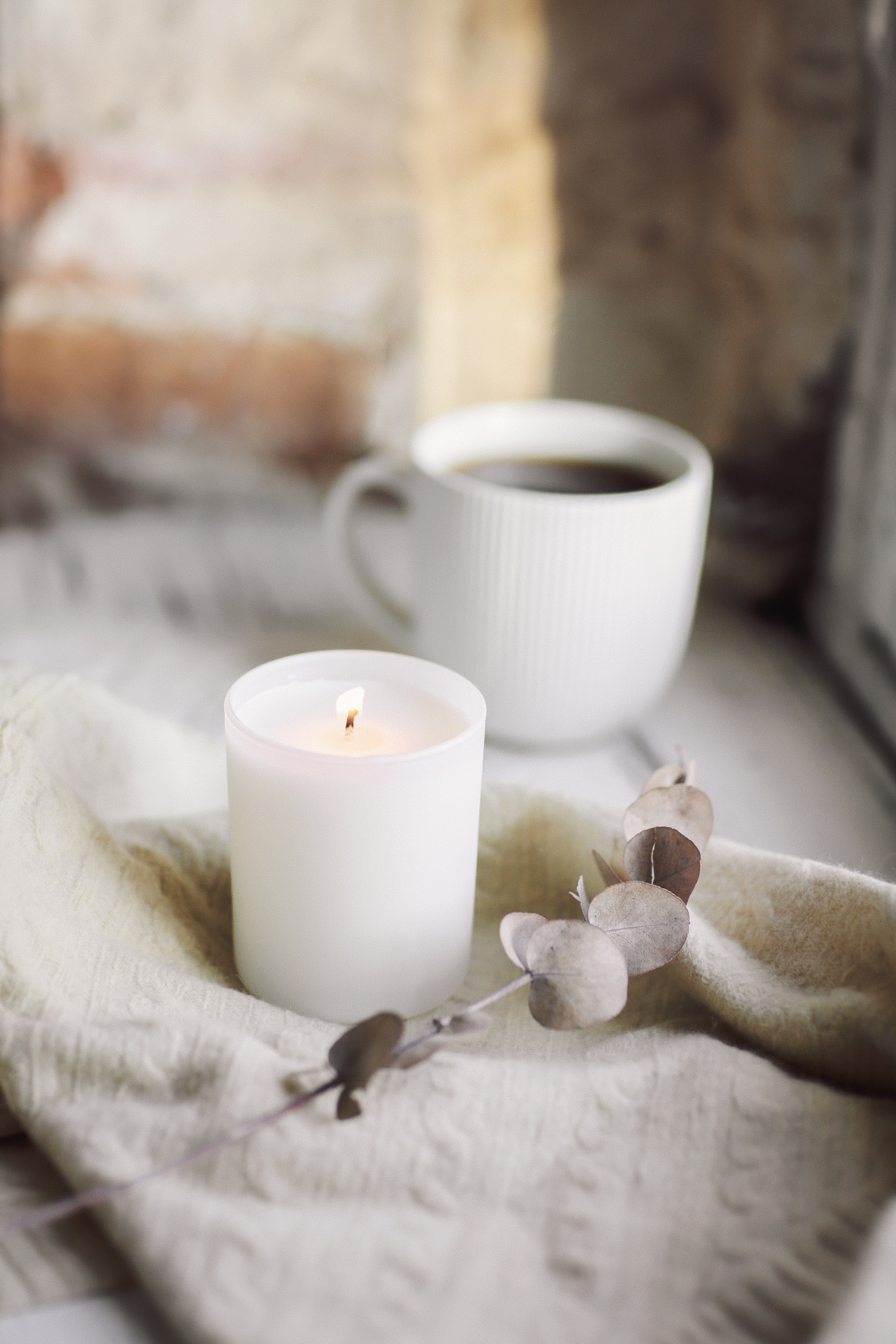 A candle and a cup of coffee on a quiet table