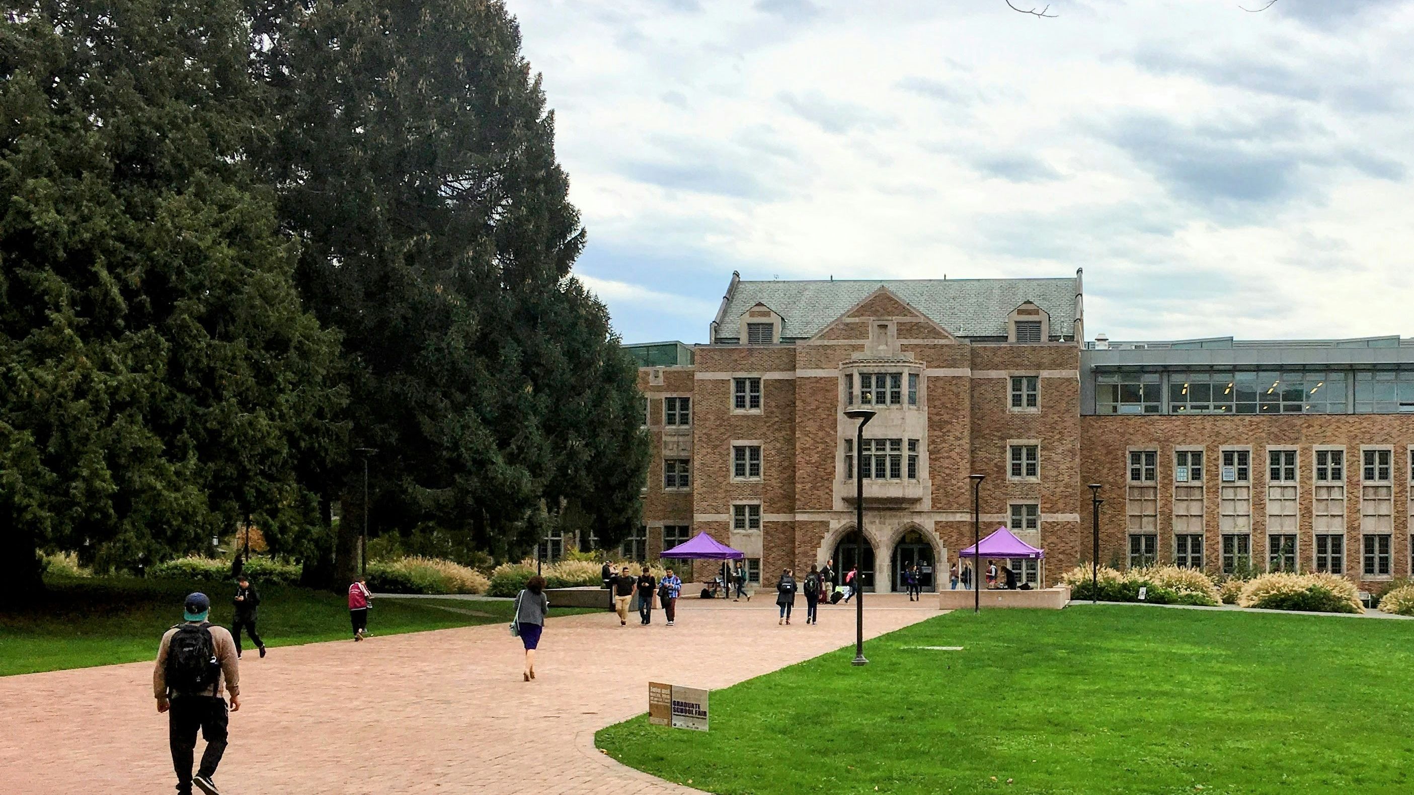 Image of people walking toward a college campus, part of FutureU's College Visit Series — When to Start Visiting Colleges, a grade-by-grade timeline