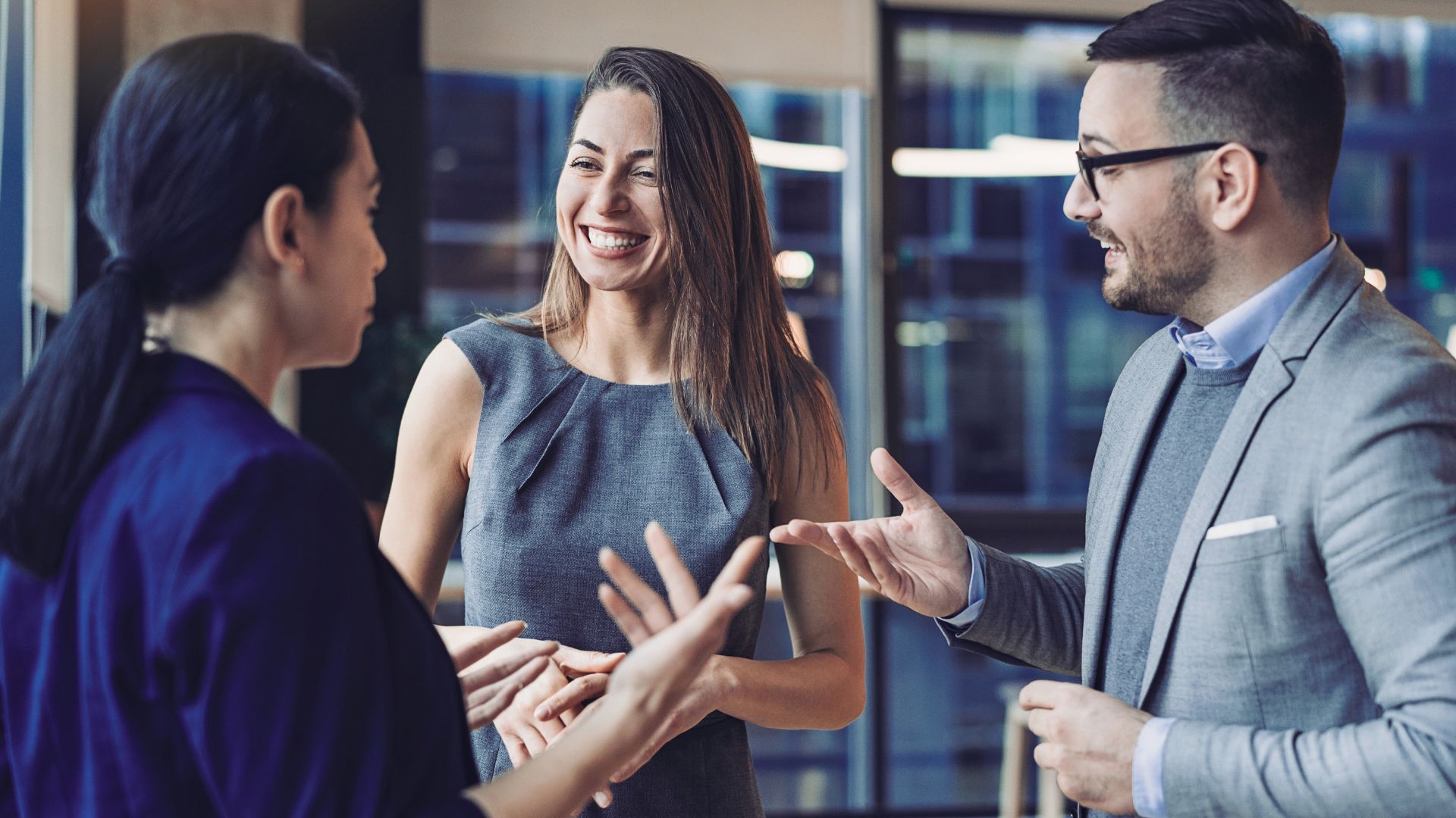 Team of professionals looking at a whiteboard while one presents in an office