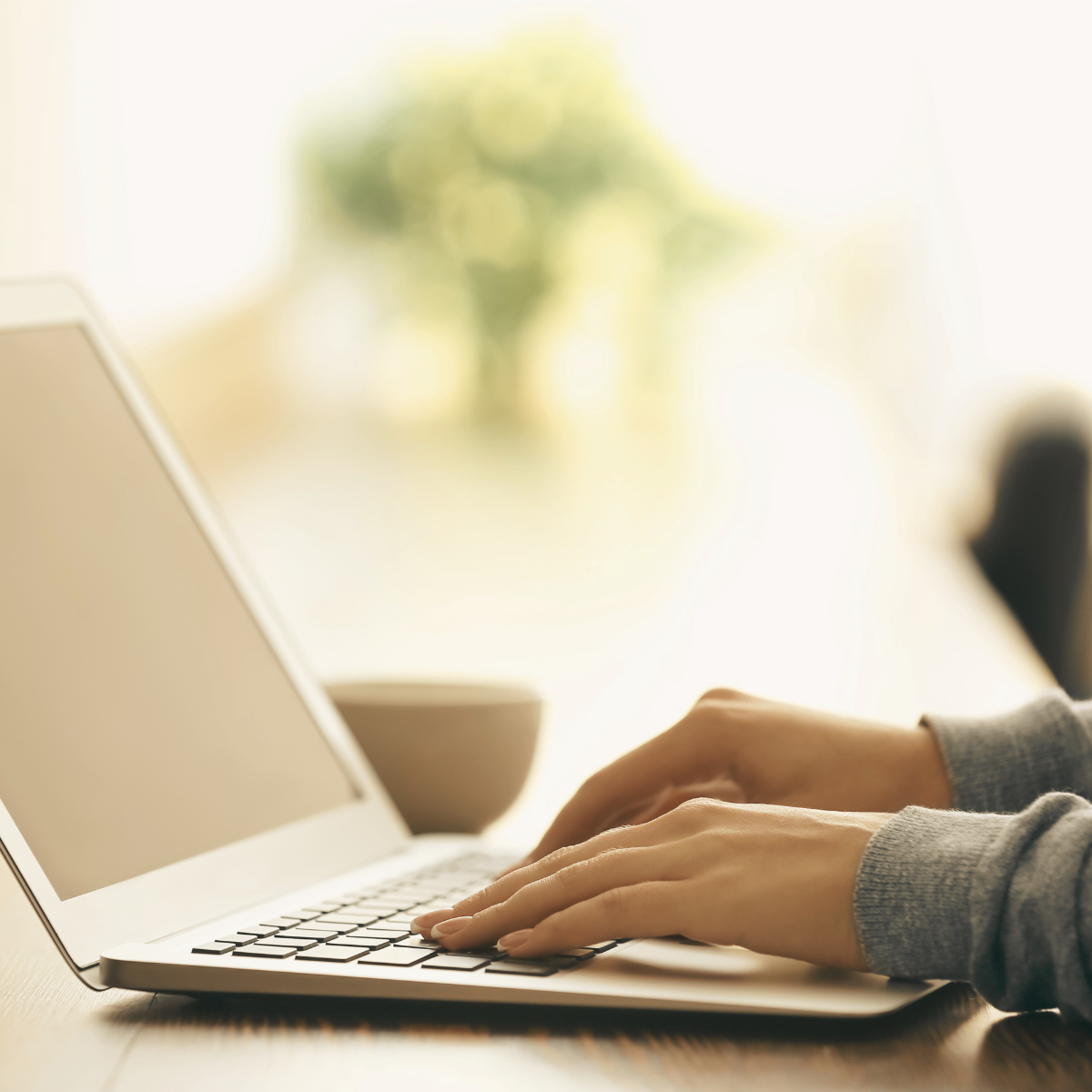 Professional man sitting at a desk in front of laptop and smiling at camera