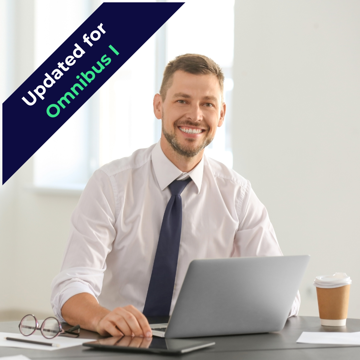 Professional man sitting at a desk in front of laptop and smiling at camera