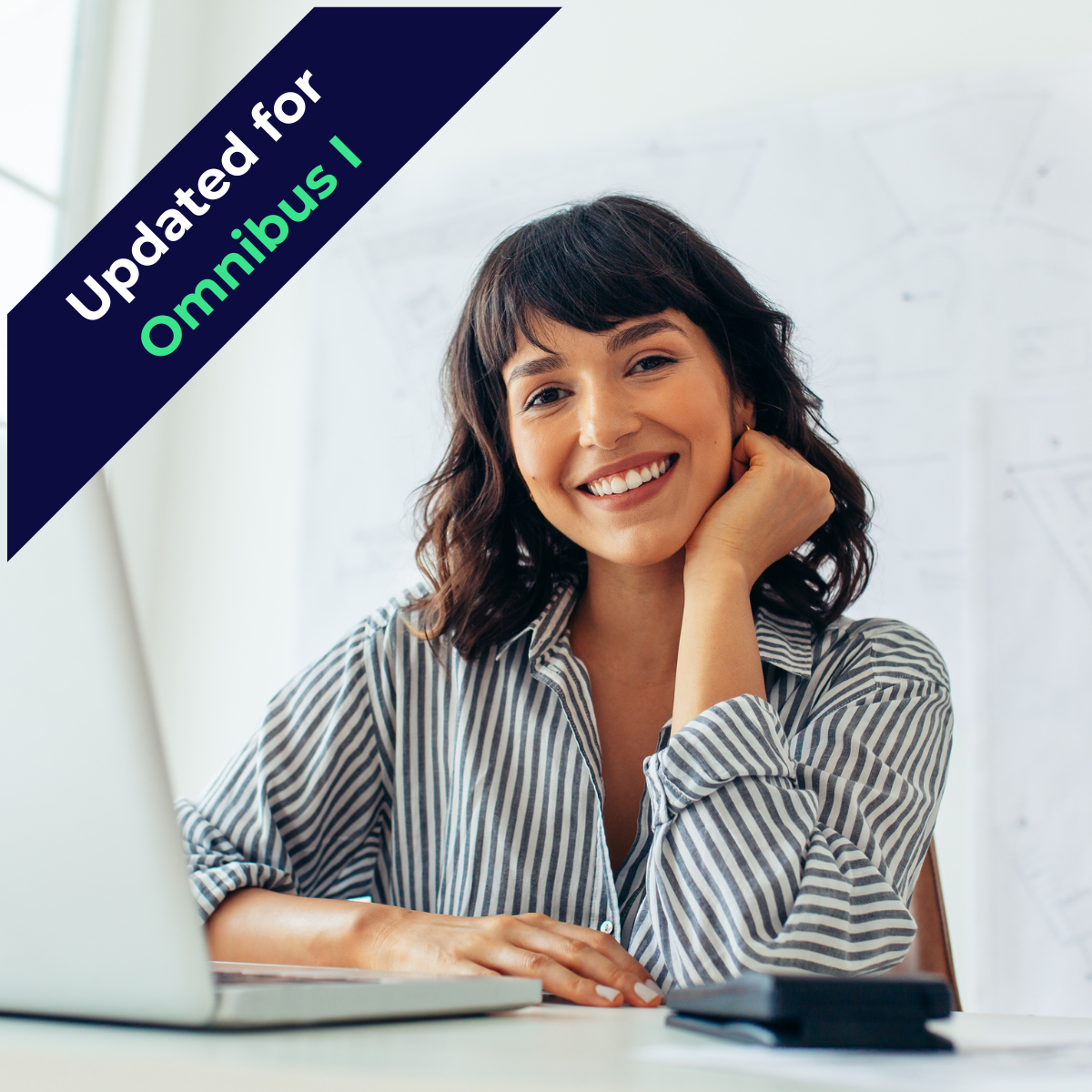Professional woman sitting at a desk in front of laptop and smiling at camera