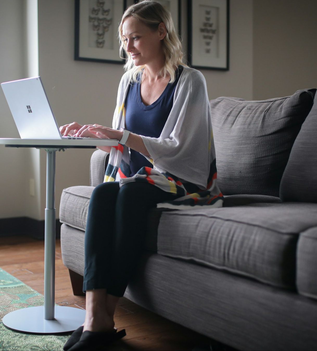 Woman sitting on couch typing on computer