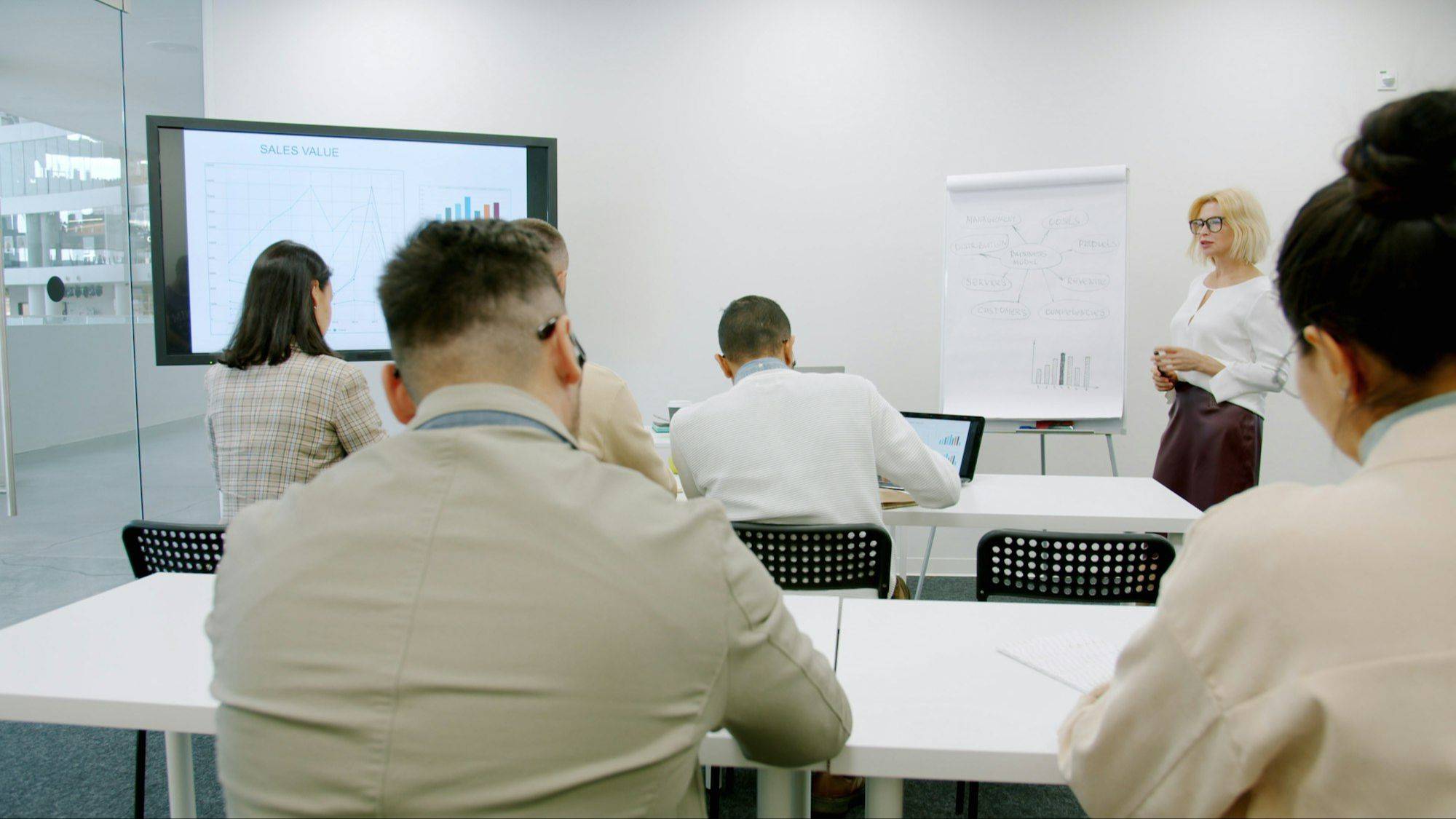Facilitator leading a professional training session with participants in a modern conference room