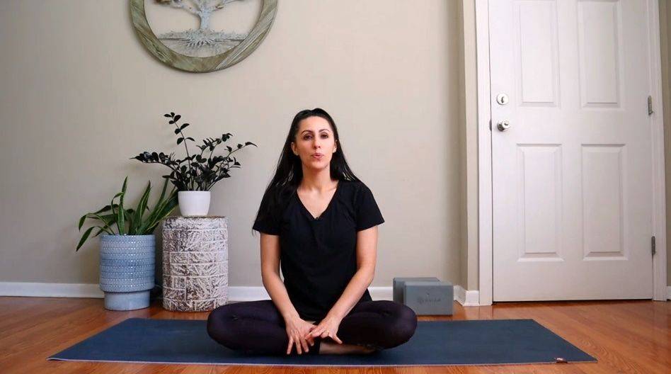 Dr. Tara Salay seated on a yoga mat introducing her guided series