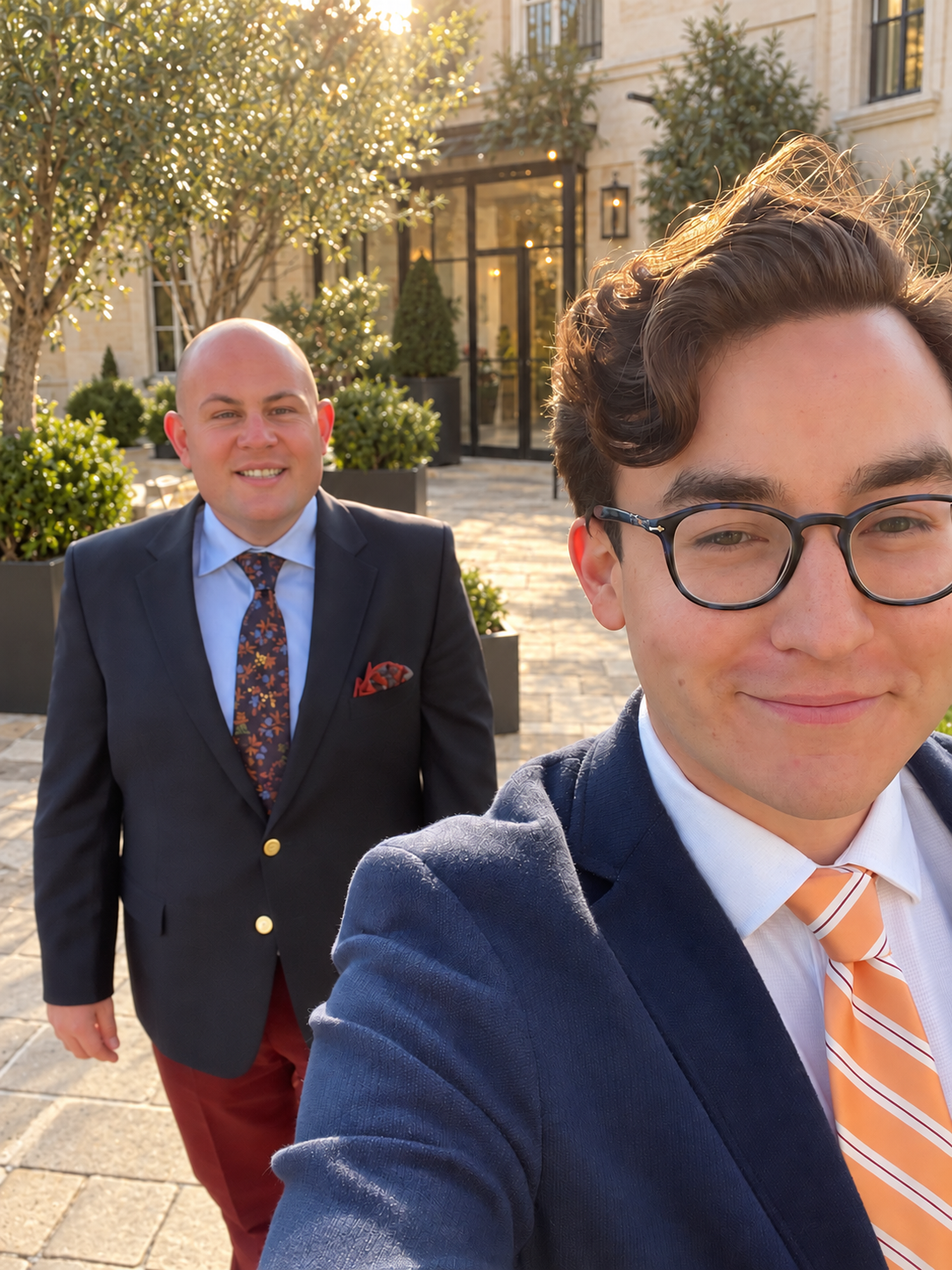 Sam on the left and Spencer on the right, wearing jackets and ties outdoors