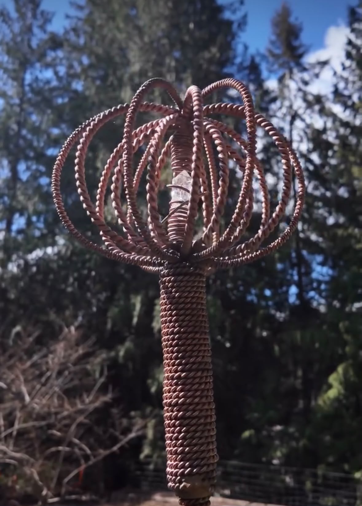 The woven copper crown and quartz heart of a Homestead Harmonizer Antenna System among the cedars