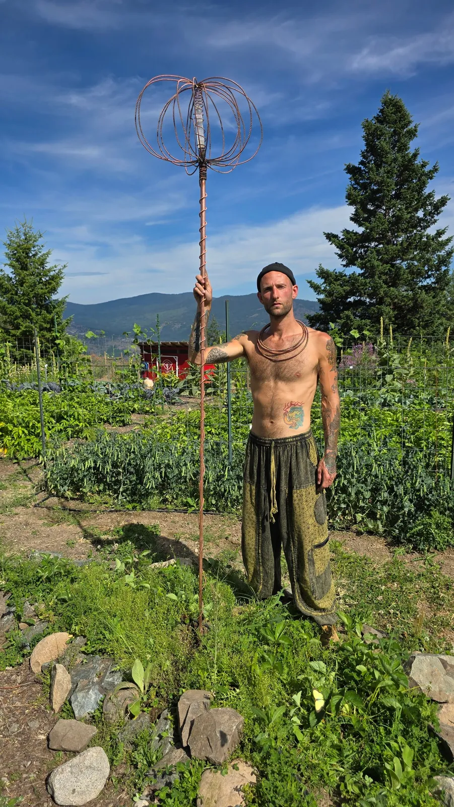 Standing beside a full-height Harmonizer Antenna System in a mountain garden