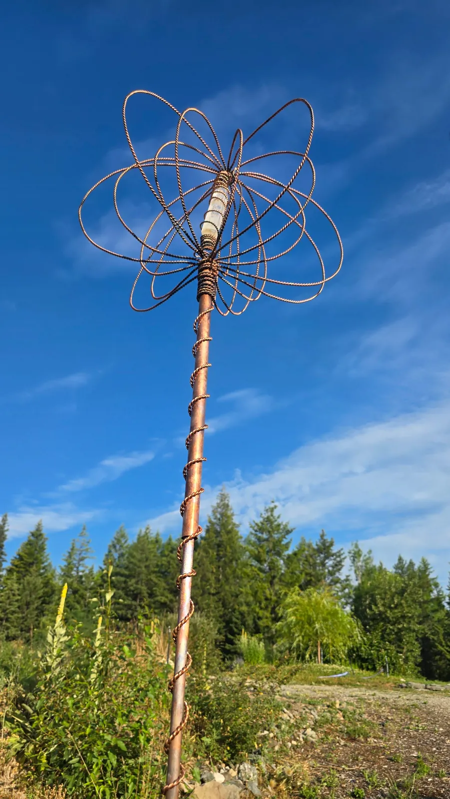The woven copper crown, quartz heart and spiral-wrapped mast of a Harmonizer Antenna System against a clear sky