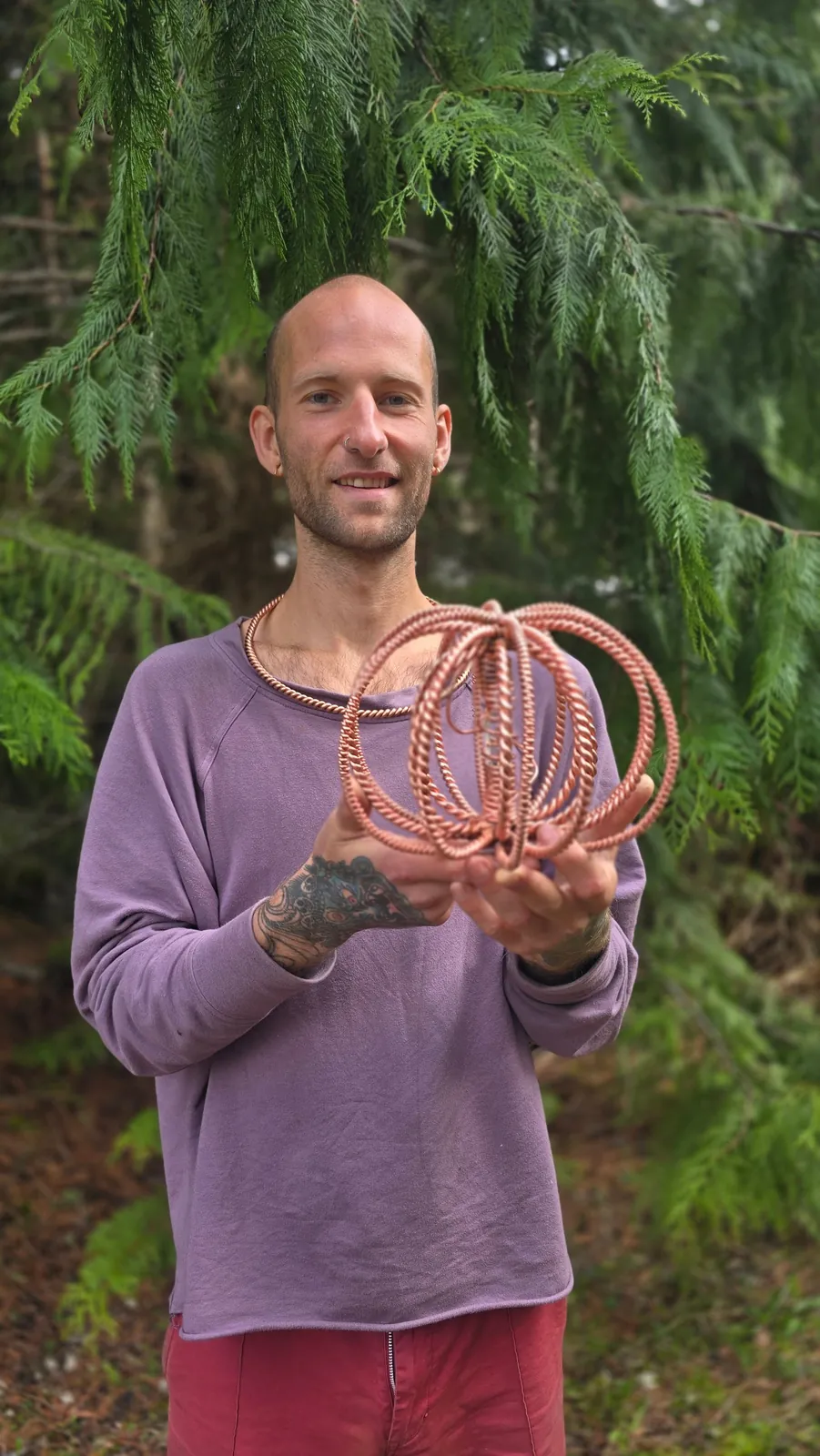 Holding the woven copper crown of a Harmonizer Antenna System among the cedars