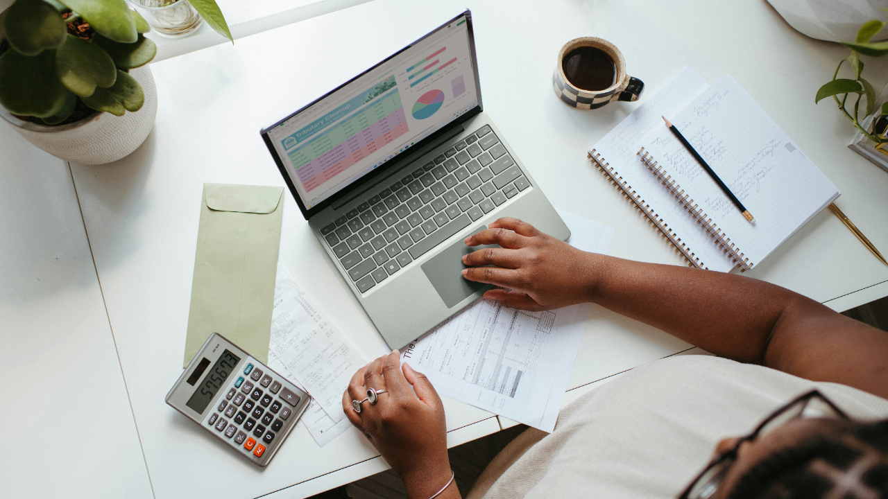laptop with hands typing. Desk set up as someone doing business