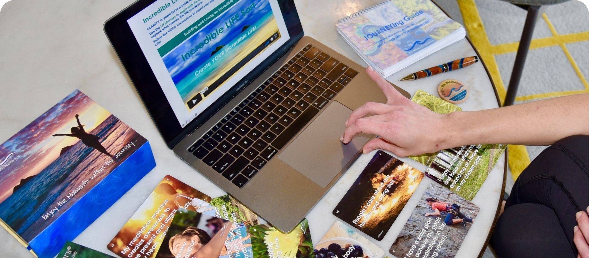 LIFEDrivers cards next to a laptop showing the online Explorer Experience course, with the JOURNEYing Guide workbook nearby