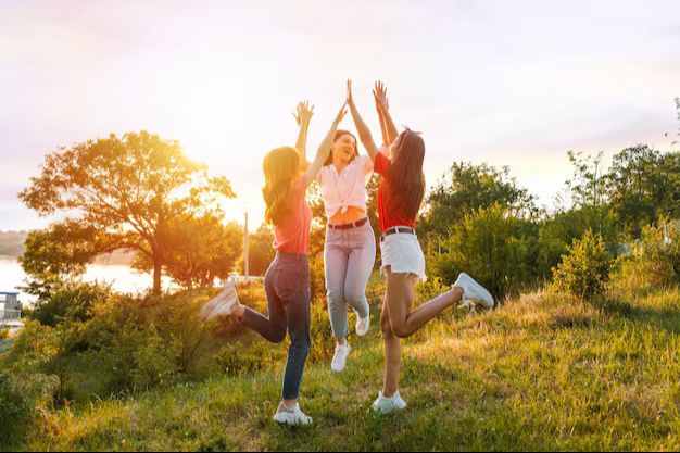Women jumping outdoors at sunset