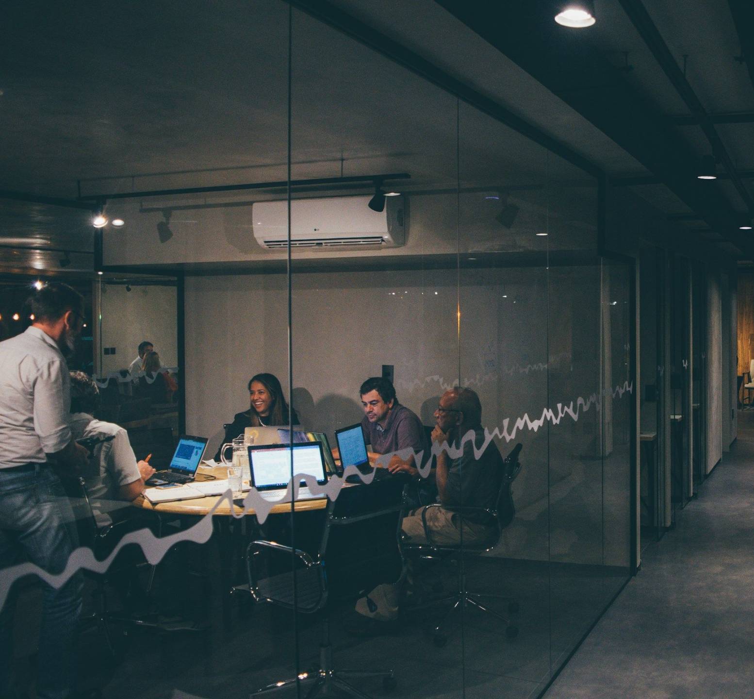 work room with 4 people on laptops doing work