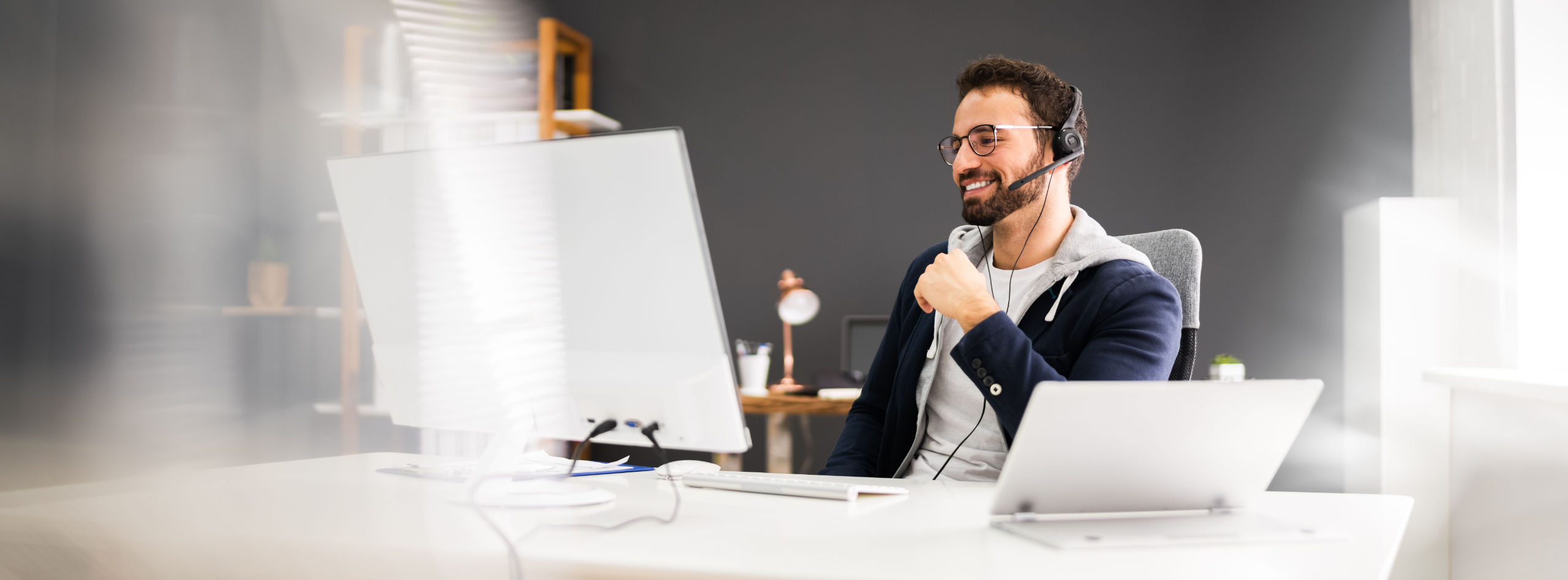 Professional coach working at desk with headset, representing supported and protected coaching practice