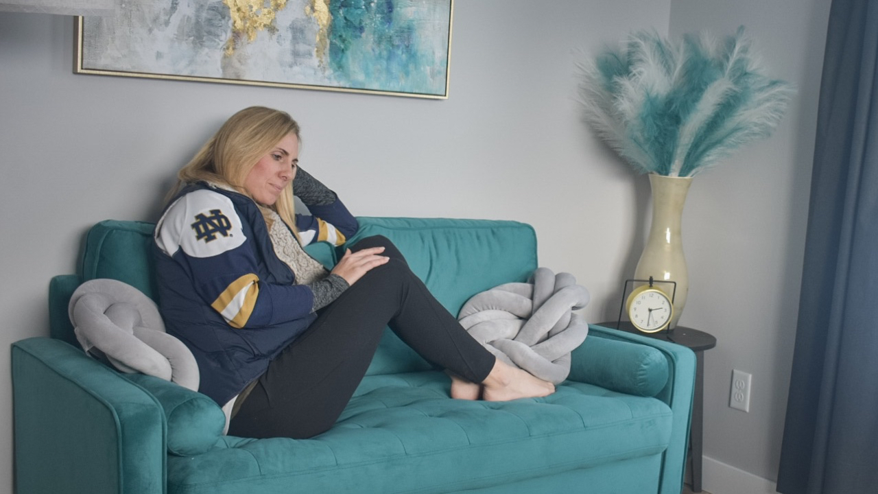 Andrea Eriks, Mother sitting alone on a couch looking emotionally drained, symbolizing the invisible emotional load and mental labor of parenting