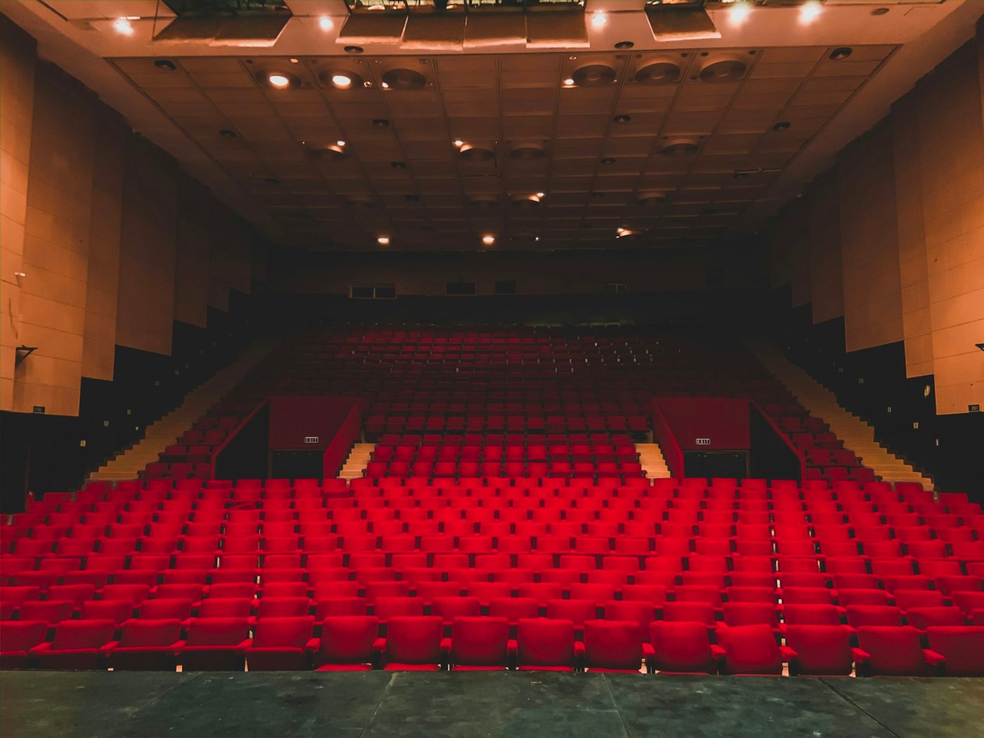 Rows of empty red seats in a theatre auditorium