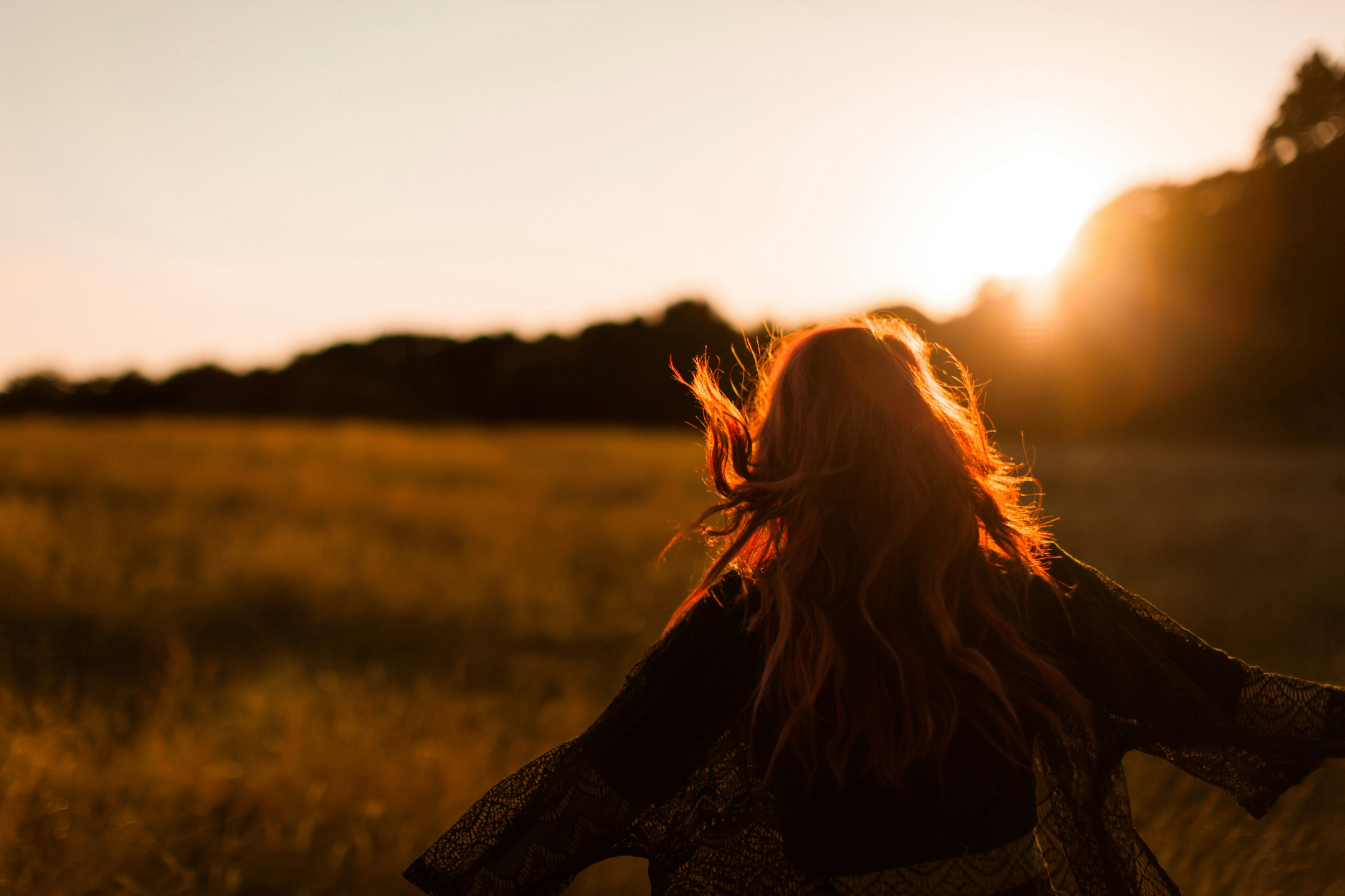 girl running in field in sunset light happy freedom 