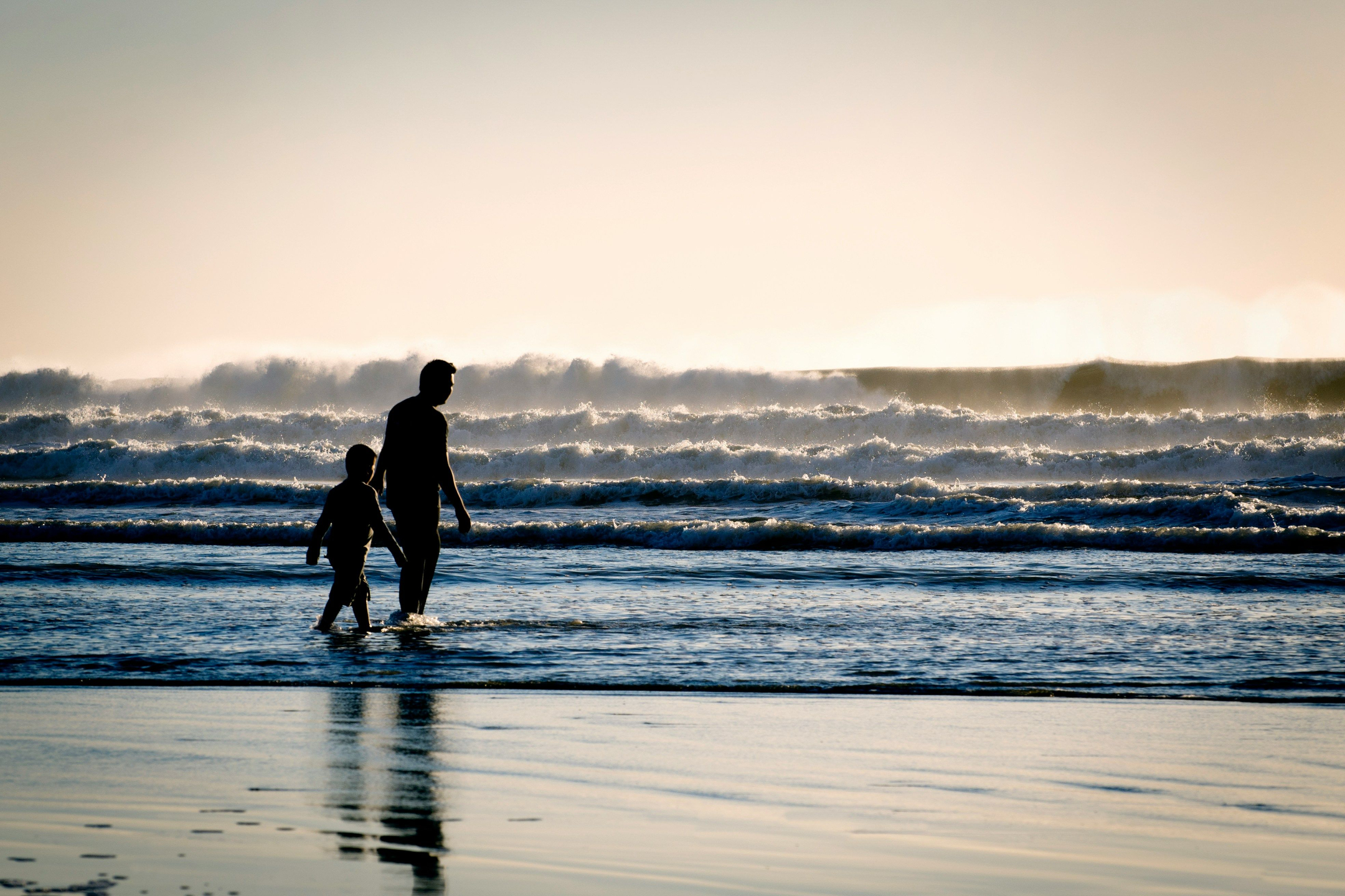 father and child homeschooling freedom walking on the beach beautiful ocean