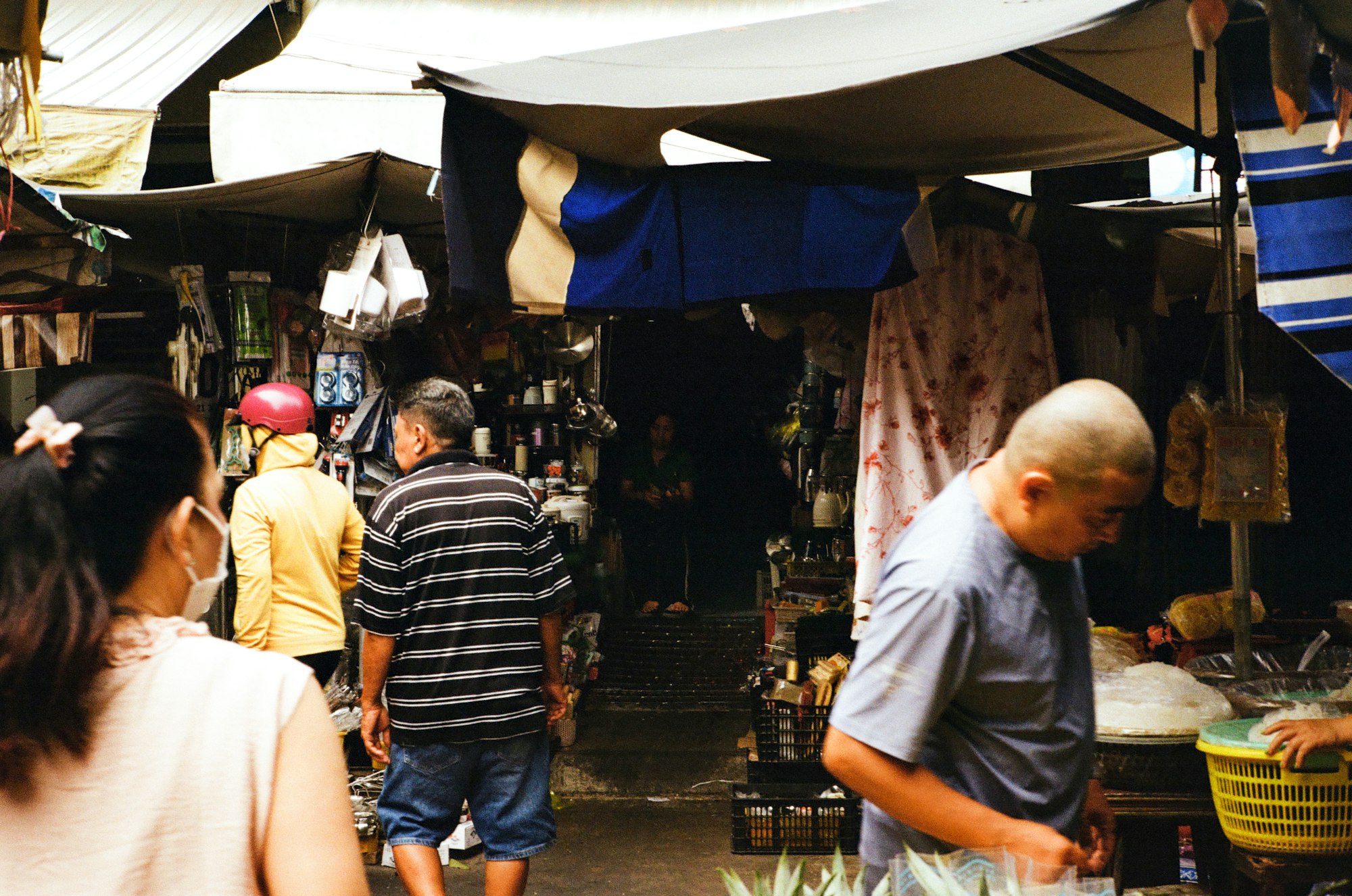 Shoppers and a vendor moving through a covered market