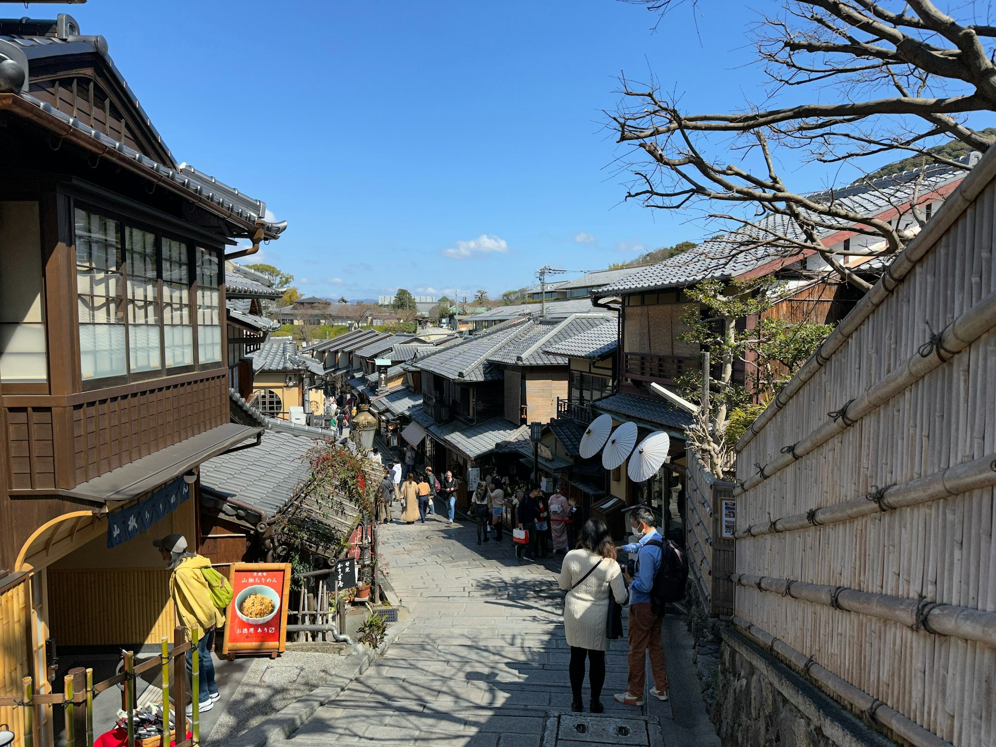 A couple walking down a lane of traditional wooden buildings in Japan