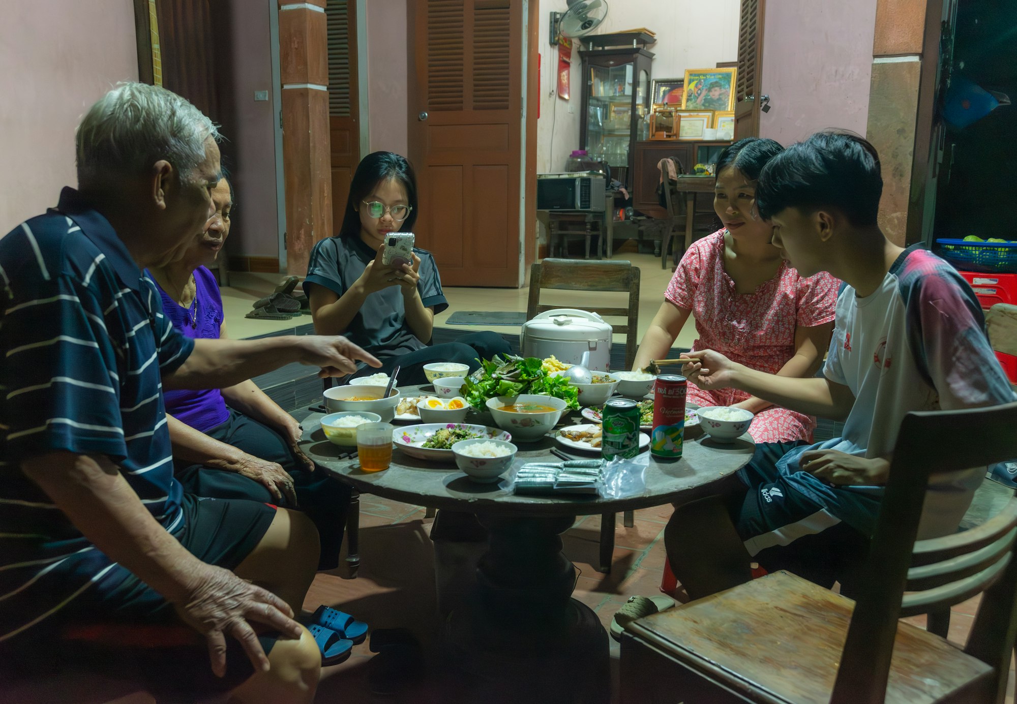 A multigenerational family eats dinner around a small round table