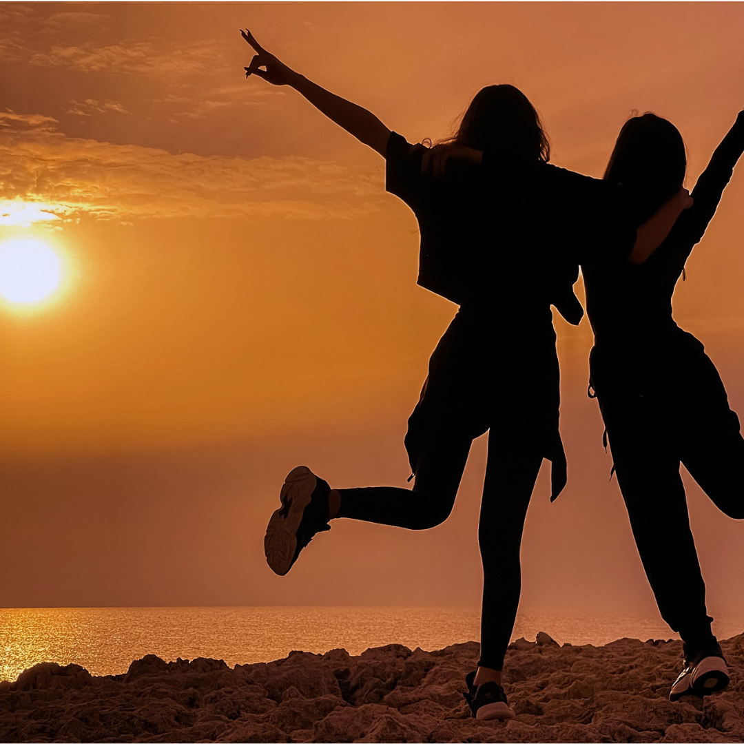Deux filles heureuses face à un coucher de soleil