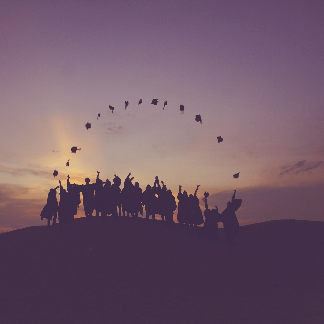 Des finissants lançant leur chapeau de graduation