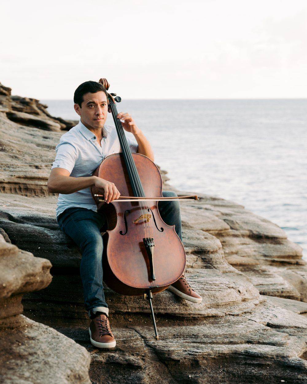 Josh playing cello on the coast
