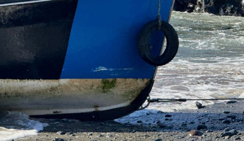 Close-up of a blue fishing boat on the Cornwall shoreline, capturing the coastal colours and textures that inspire David Mankin's contemporary abstract landscape paintings.