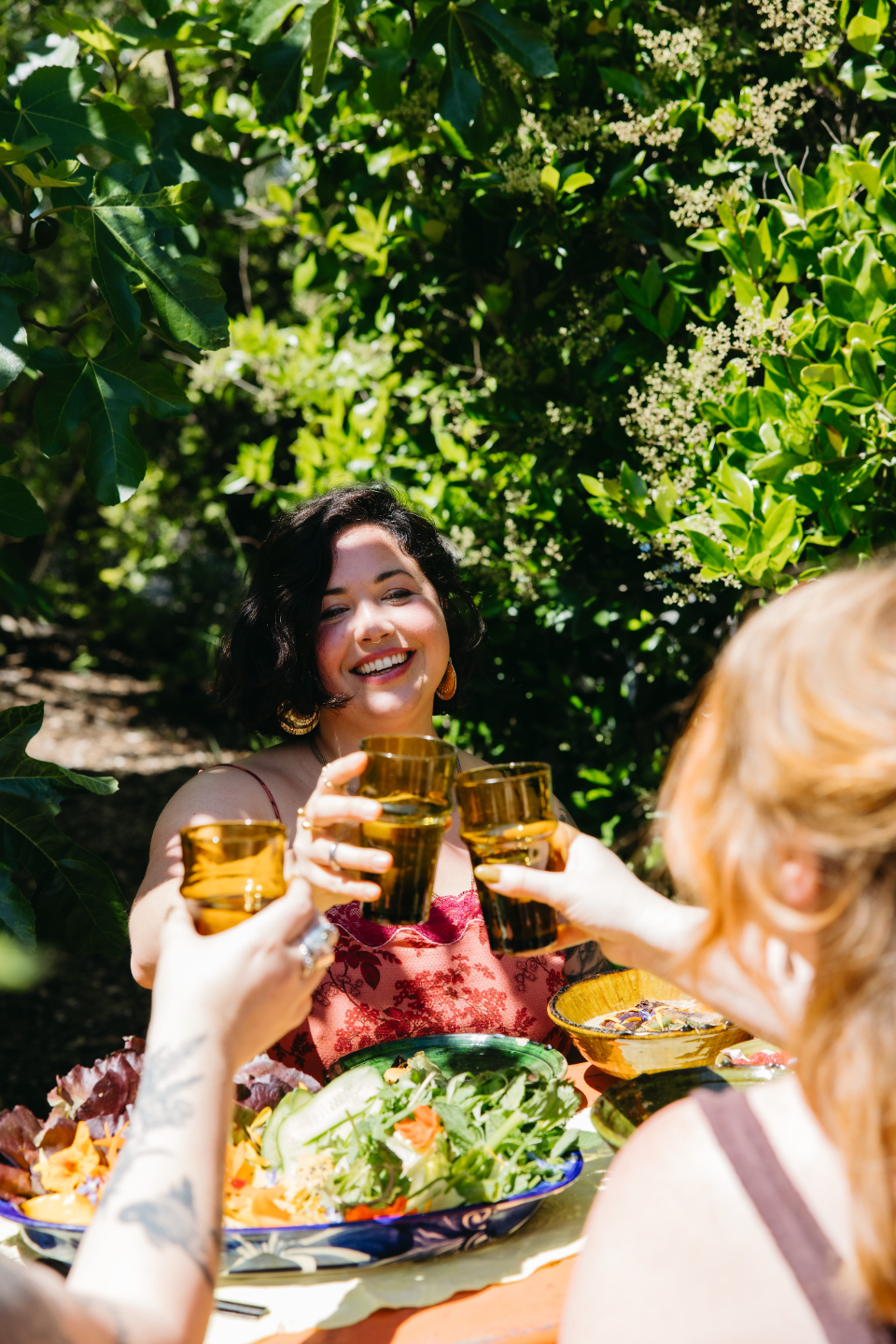 A richly styled wooden bowl filled with an abundance of dried roots, medicinal mushrooms, bark, and botanicals, surrounded by small bowls of saffron, dried herbs, and tonic ingredients, representing the depth and potency of ancient herbal medicine traditions
