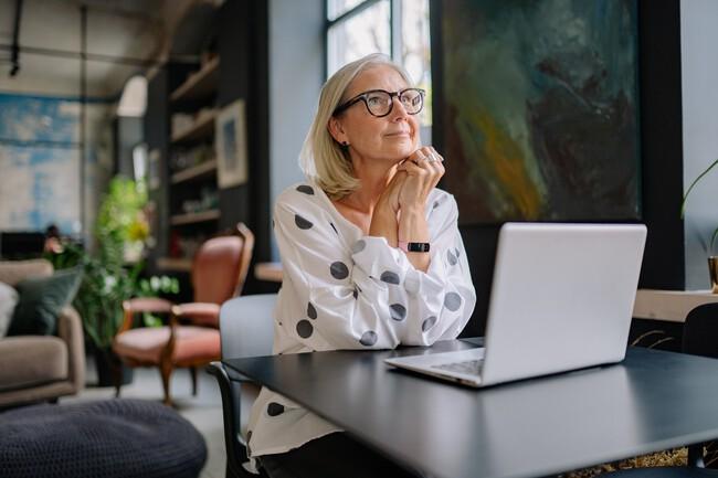 Mature woman sitting thoughtfully at a table