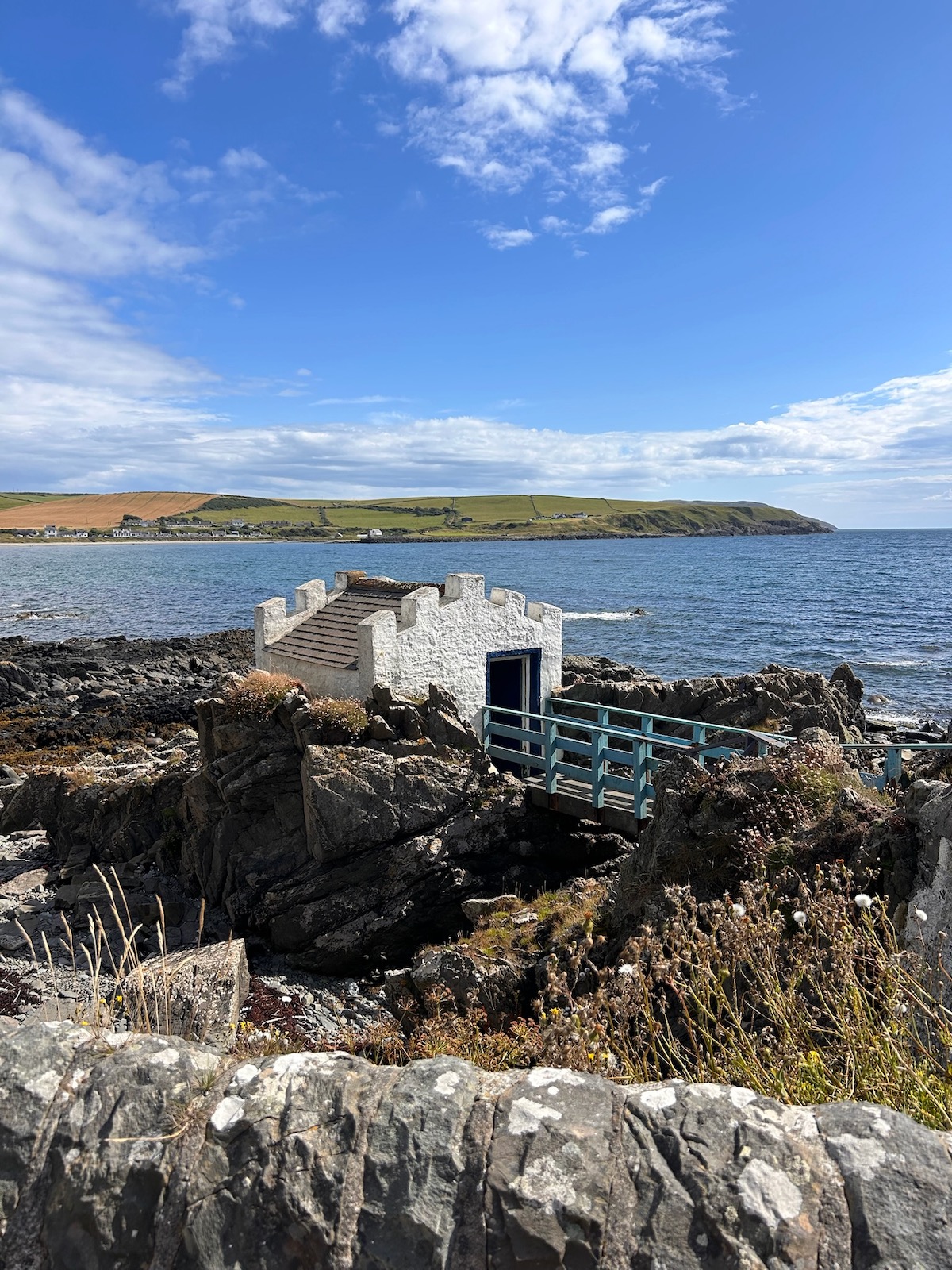 White bathing hut on a quiet rocky coastline