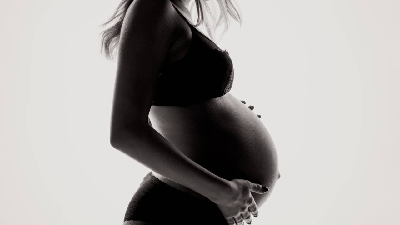 Image en noir et blanc d'une femme enceinte de profil